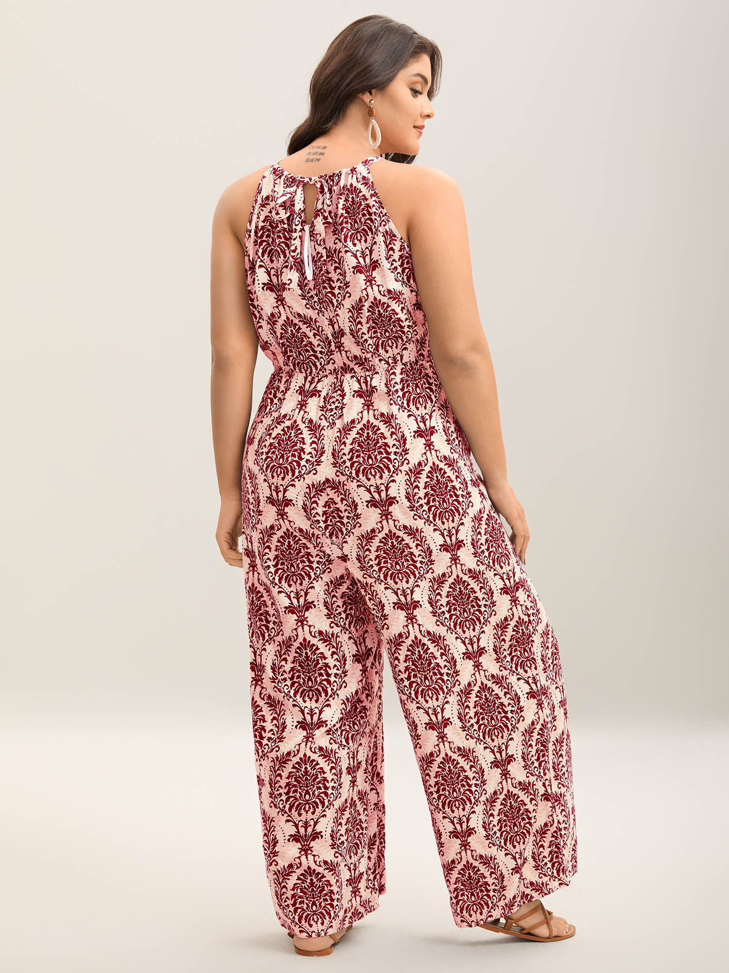 Side view of BloomChic Women's Plus Size Rayon Damask Print Stretchy Waist Jumpsuit Rust Vacation 10/M