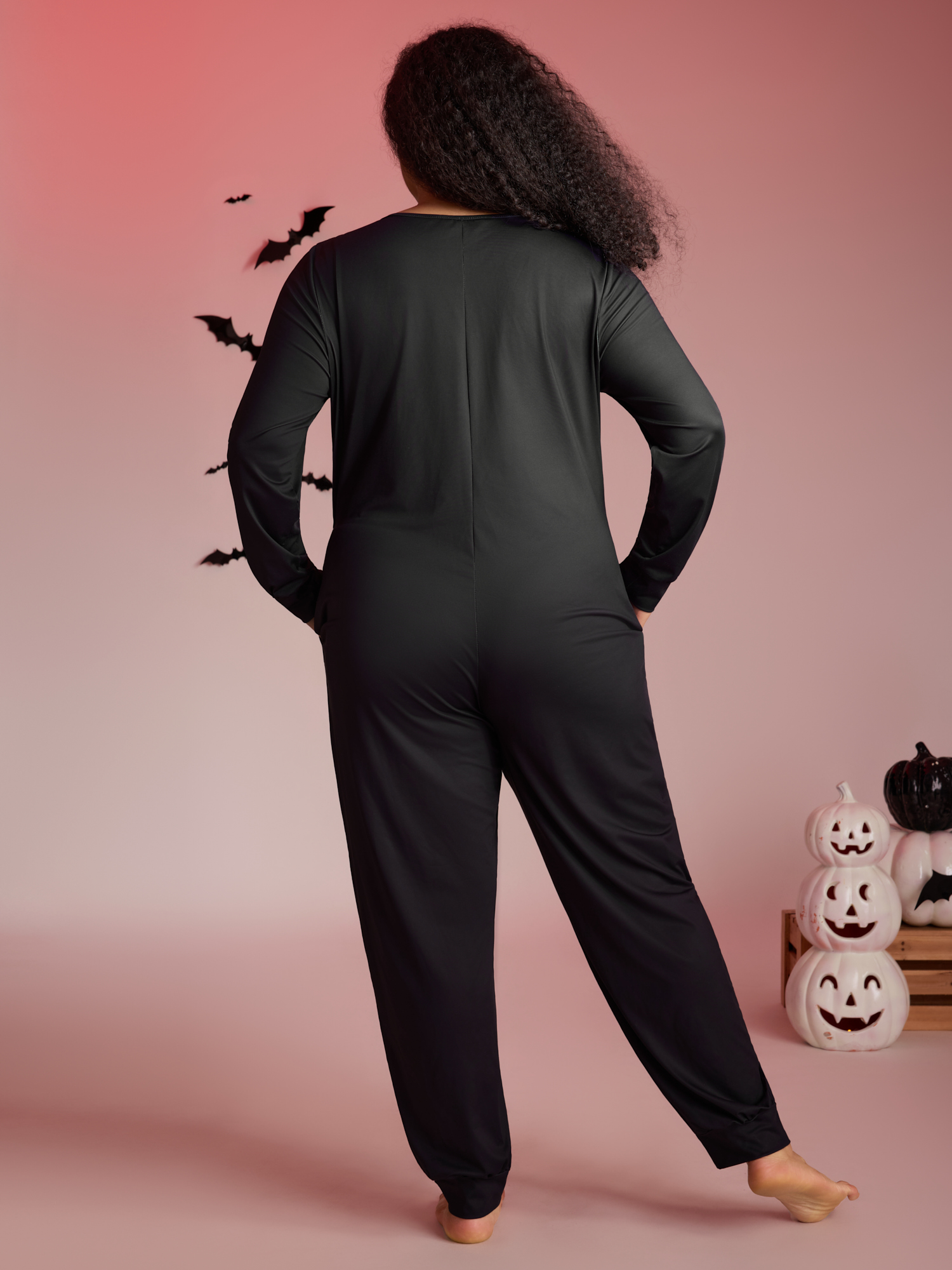 Side view of BloomChic Women's Plus Size Skeletal Rib Print Hidden Zipper Lounge Jumpsuit Black 14-16/1X