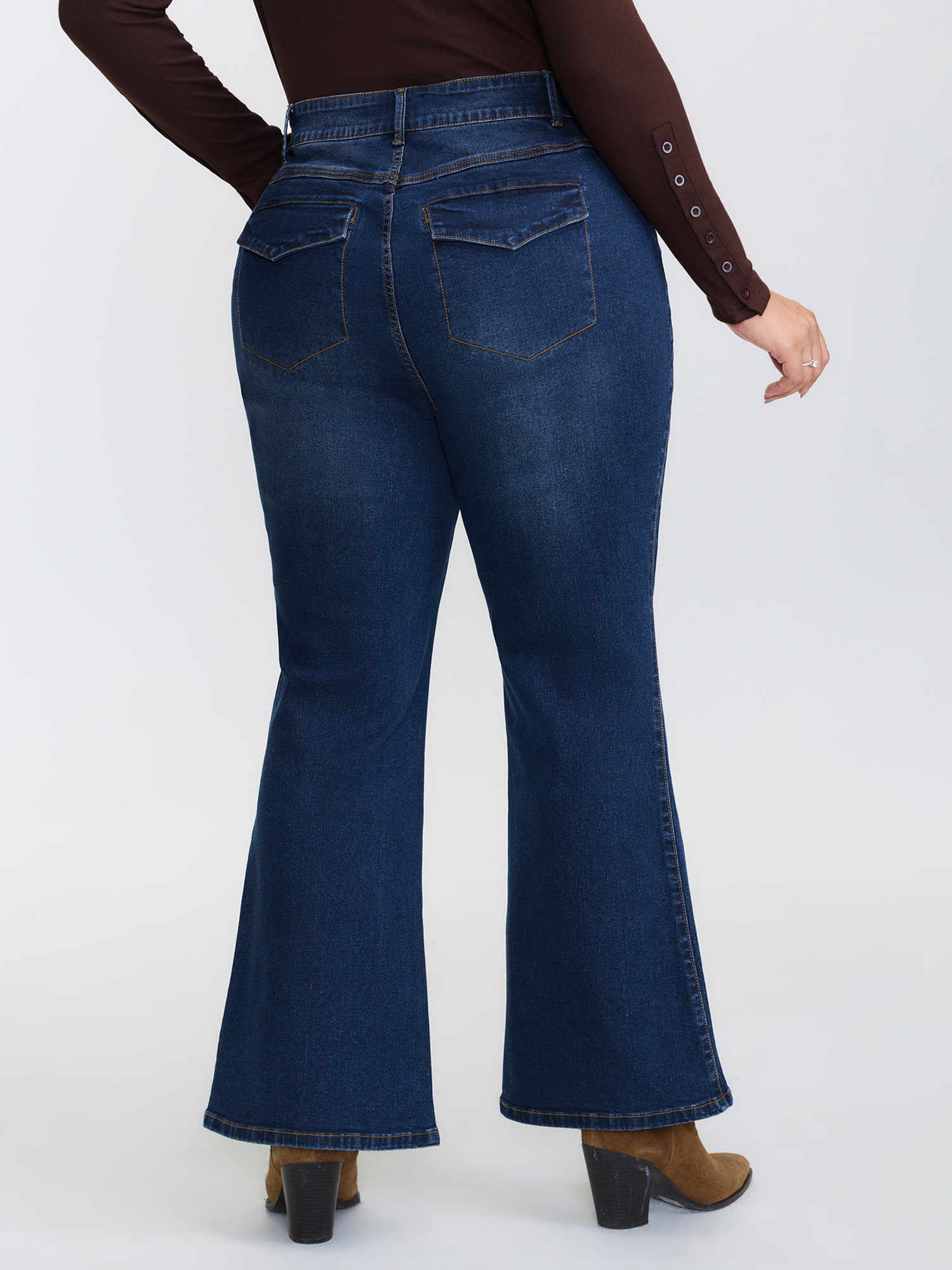 Side view of BloomChic Women's Plus Size Mid-Rise Flare Hem Jeans Denimindigo Flared High stretch 30/6X
