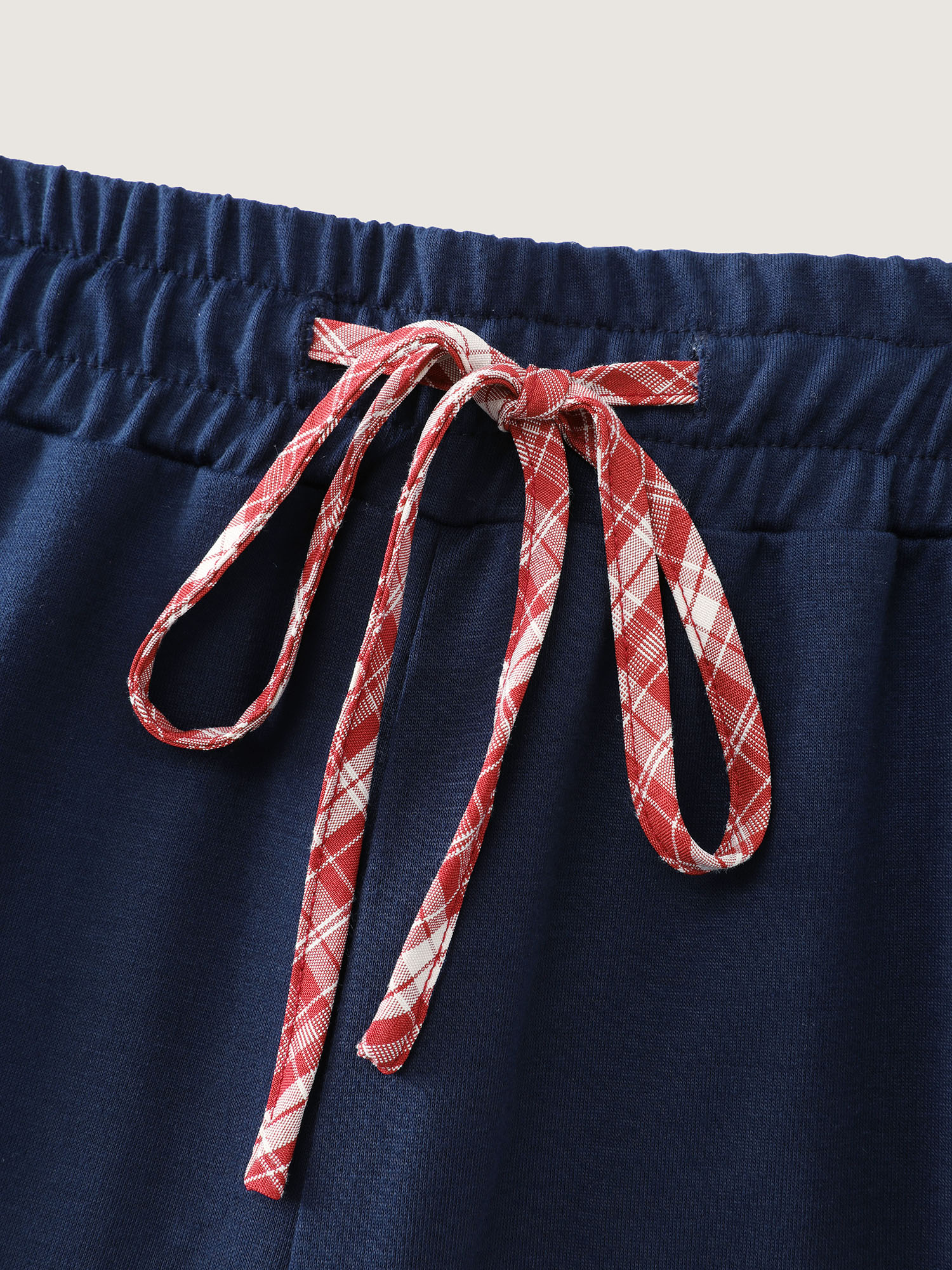 Side view of BloomChic Women's Plus Size Gingham Edges Stretchy Drawstring Lounge Bottoms Indigo Tall 30/6X