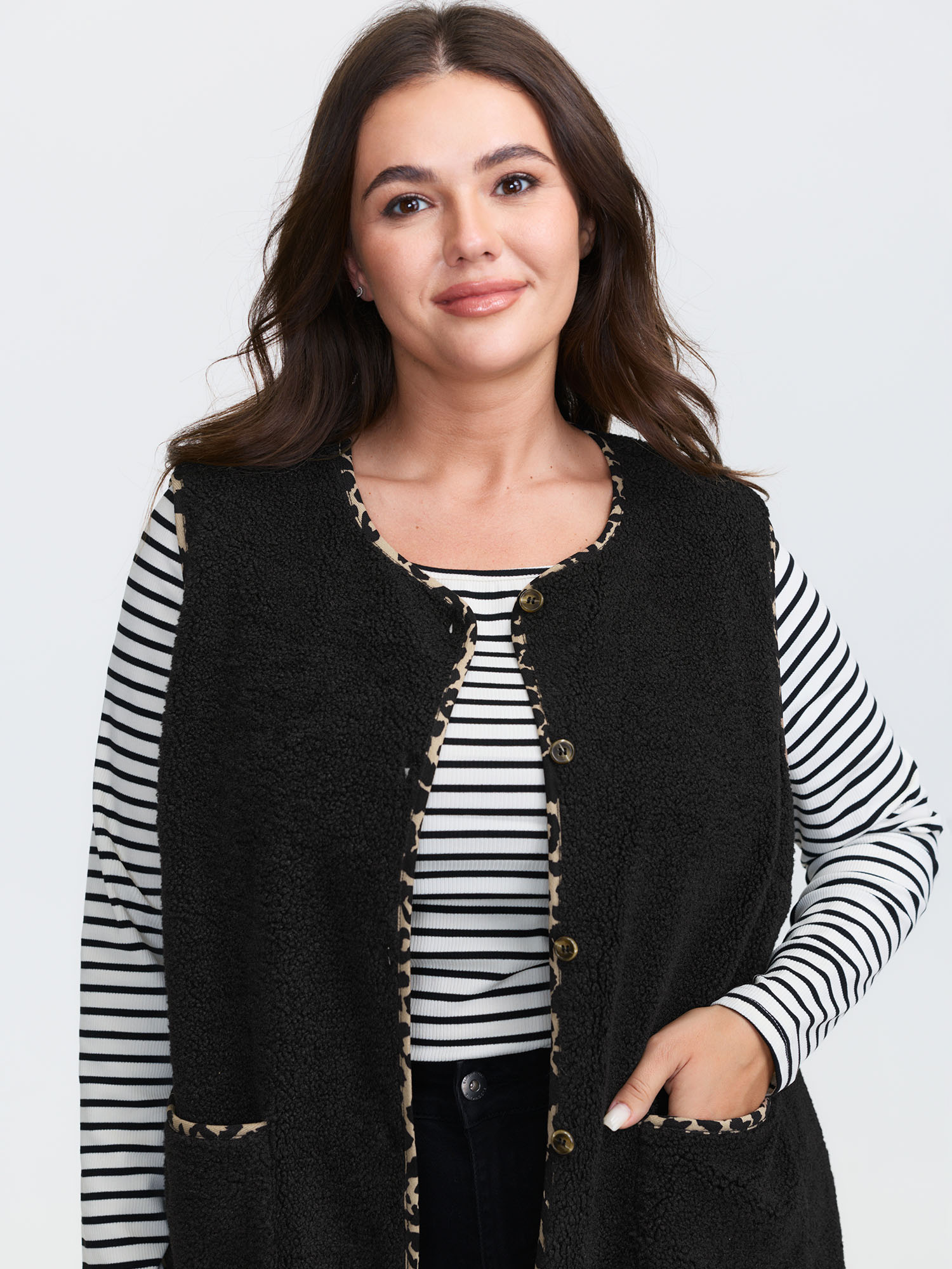 Side view of BloomChic Women's Plus Size Faux Shearling Patchwork Leopard Edge Vest Black Colorblock 14-16/1X