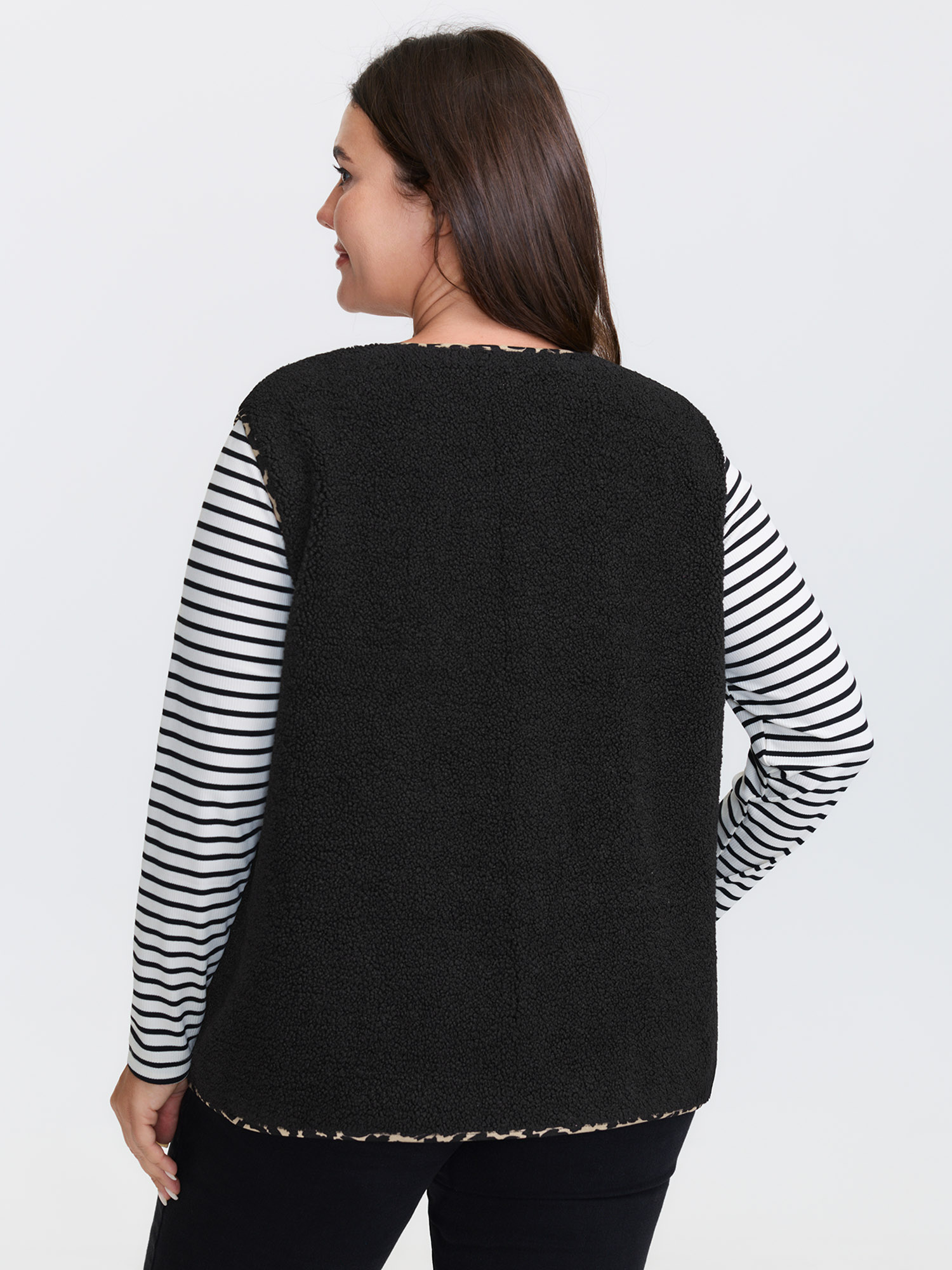 Side view of BloomChic Women's Plus Size Faux Shearling Patchwork Leopard Edge Vest Black Colorblock 14-16/1X