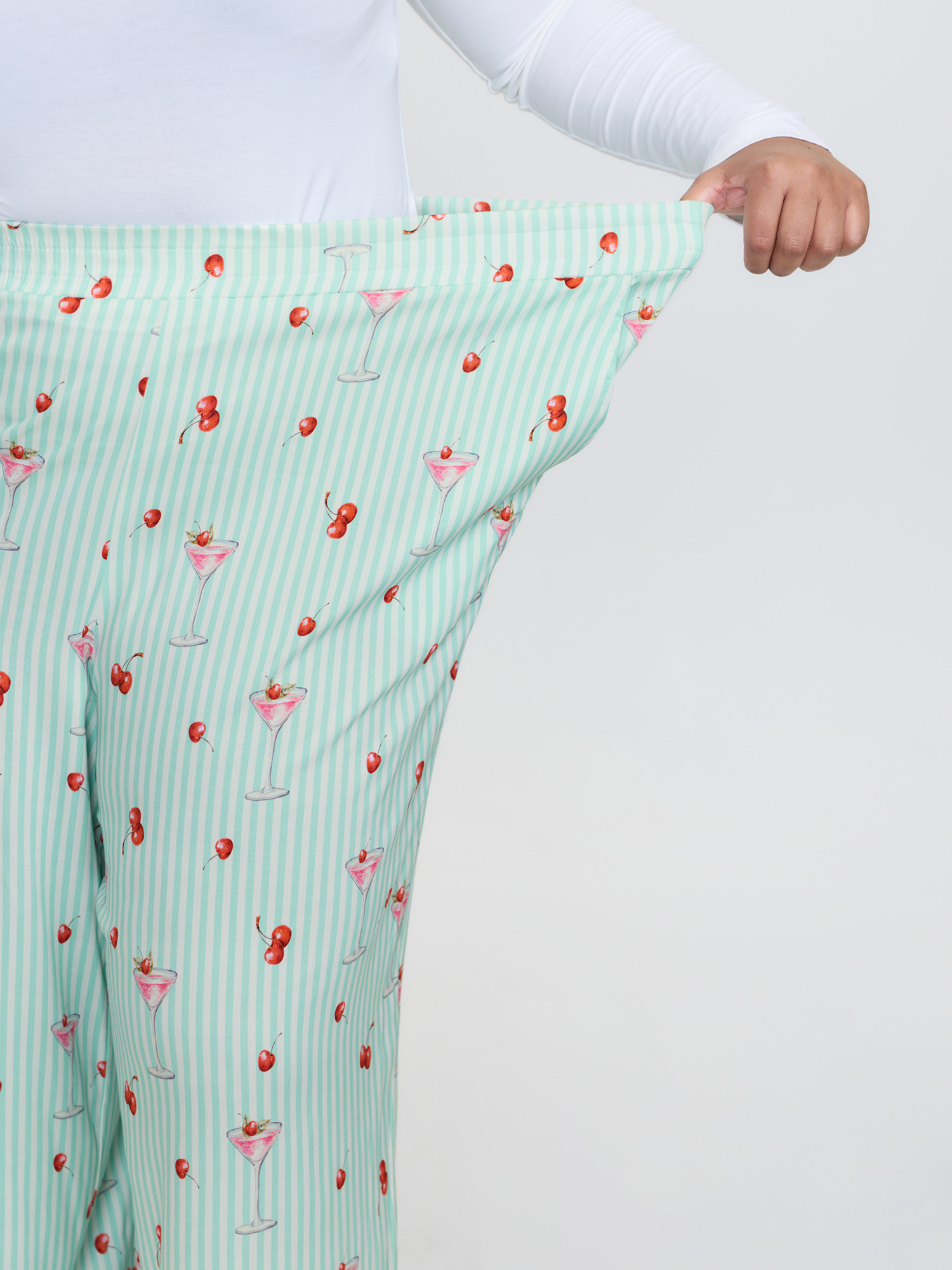 Side view of BloomChic Women's Plus Size Cherry Print Elastic Waist Pockets Pajama Bottoms Multicolor Fruit Smocked Relaxed Fit 26/4X
