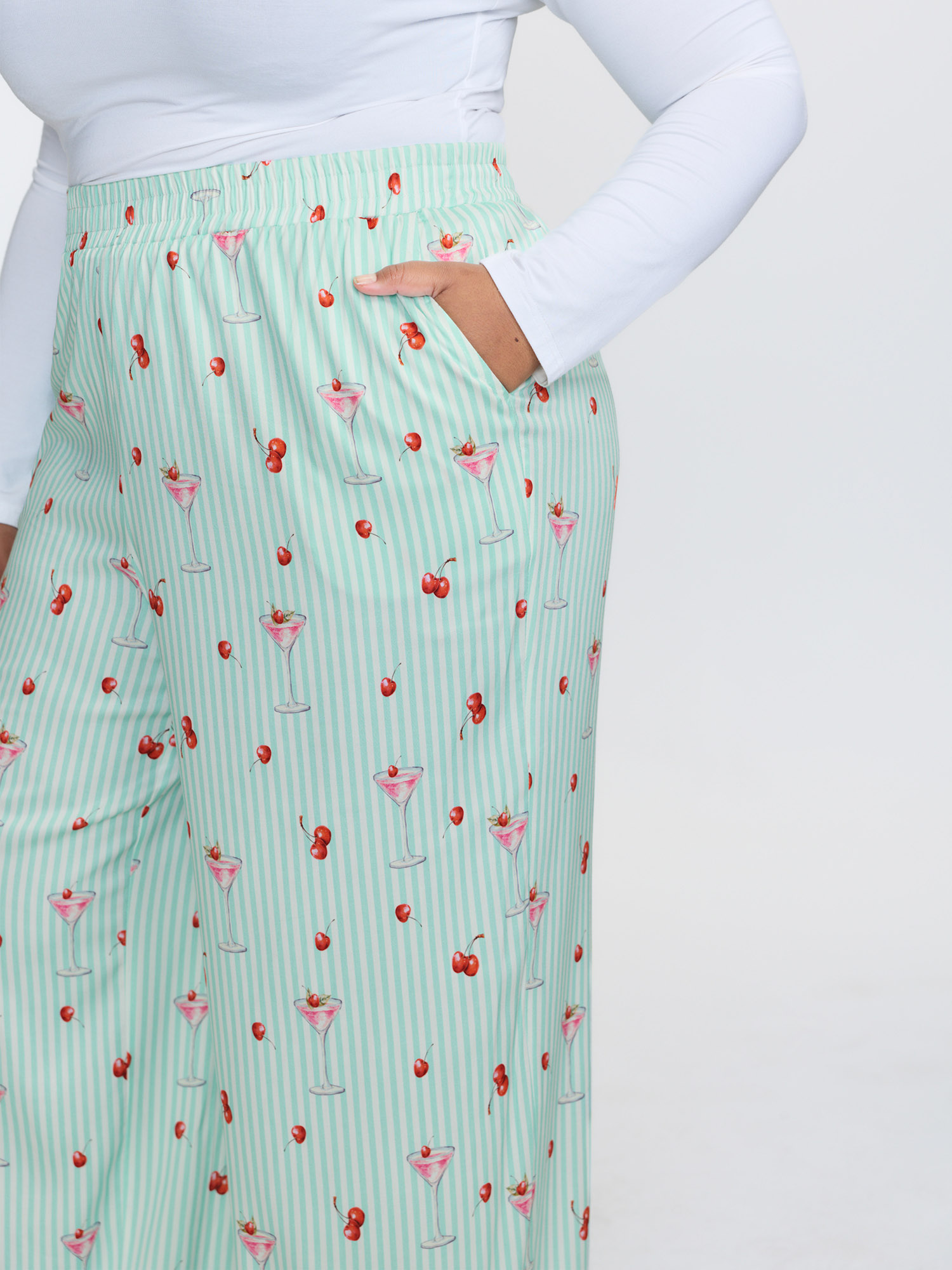 Side view of BloomChic Women's Plus Size Cherry Print Elastic Waist Pockets Pajama Bottoms Multicolor Fruit Smocked Relaxed Fit 26/4X