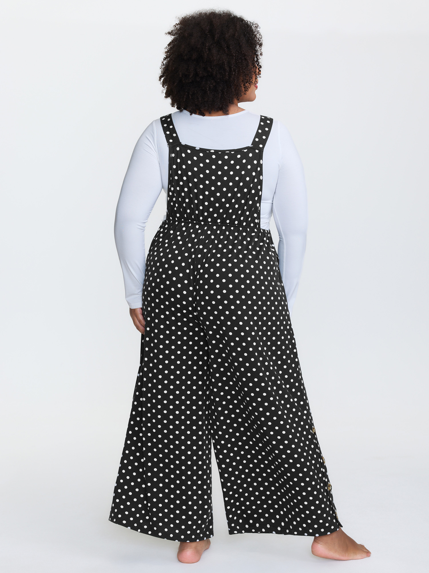 Side view of BloomChic Women's Plus Size Stretchy Polka Dots Lounge Jumpsuit Black Maxi 10/M