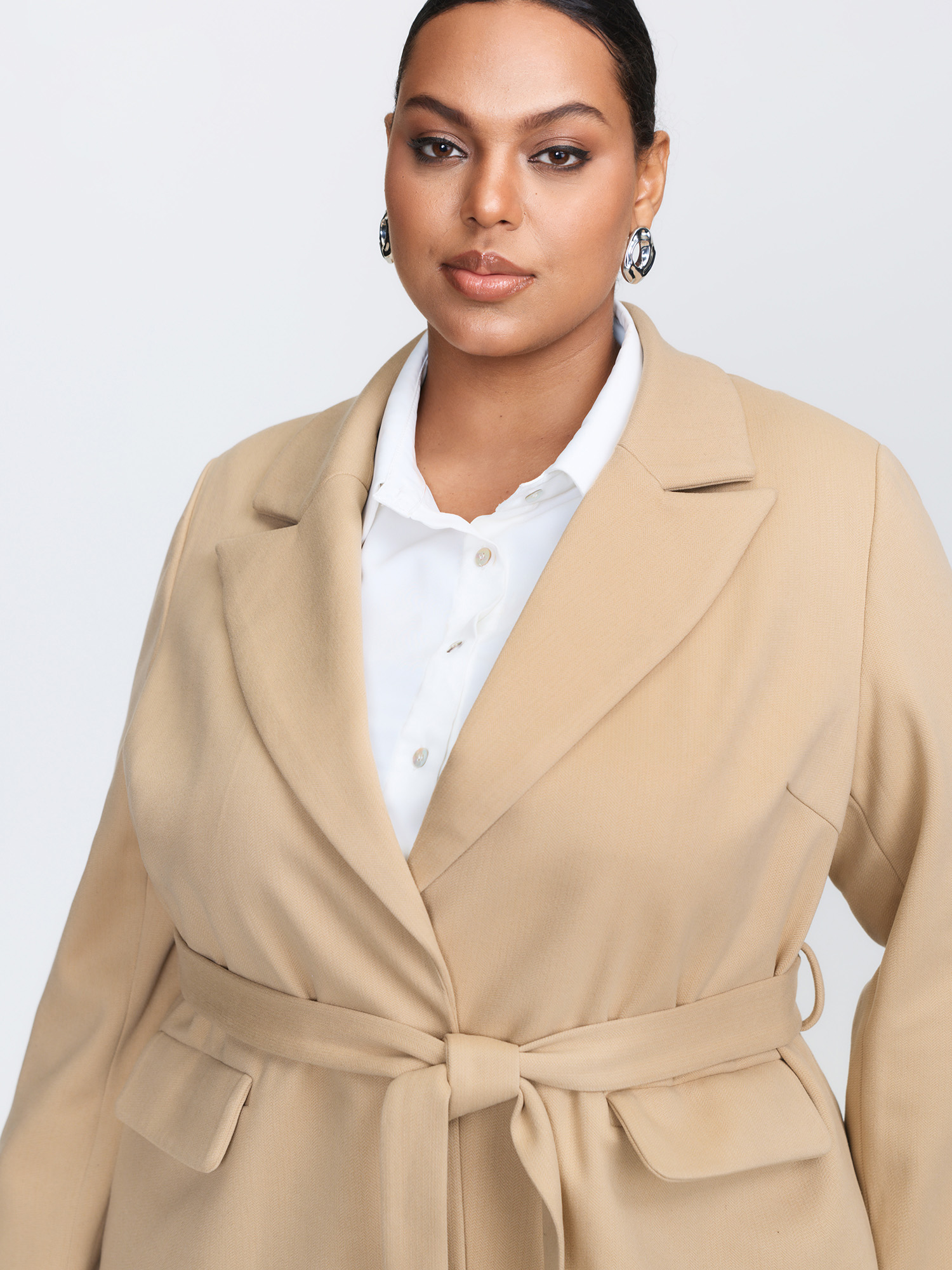 Side view of BloomChic Women's Plus Size Textured Belted Plain Blazer Tan not graphics Wide Waistband Sleeve Long Sleeve Notched Lapel 26/4X