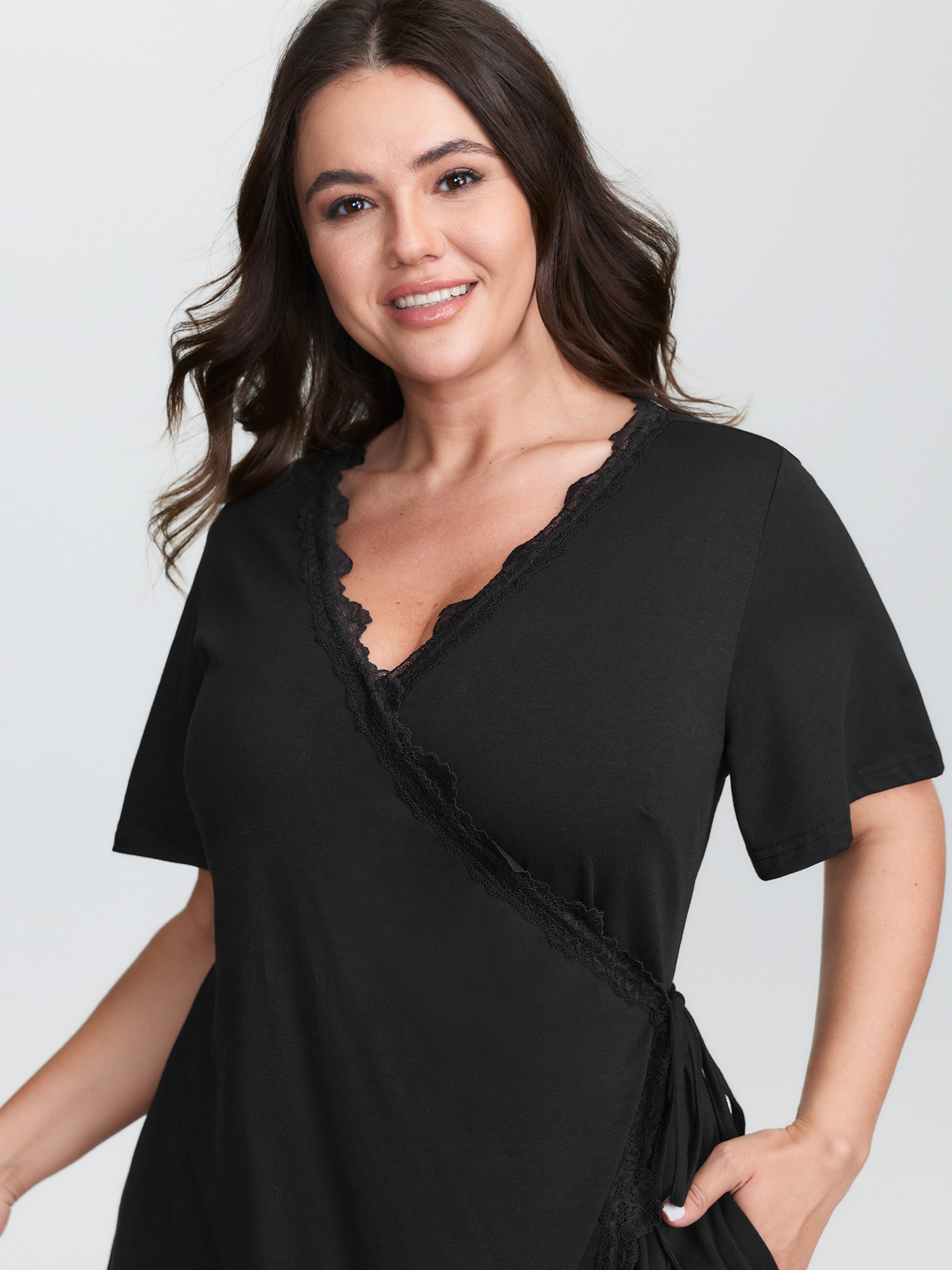 Side view of BloomChic Women's Plus Size Lace Trim Side-Tie Pockets Nightgown Black Short sleeve Mini V-Neck 30/6X