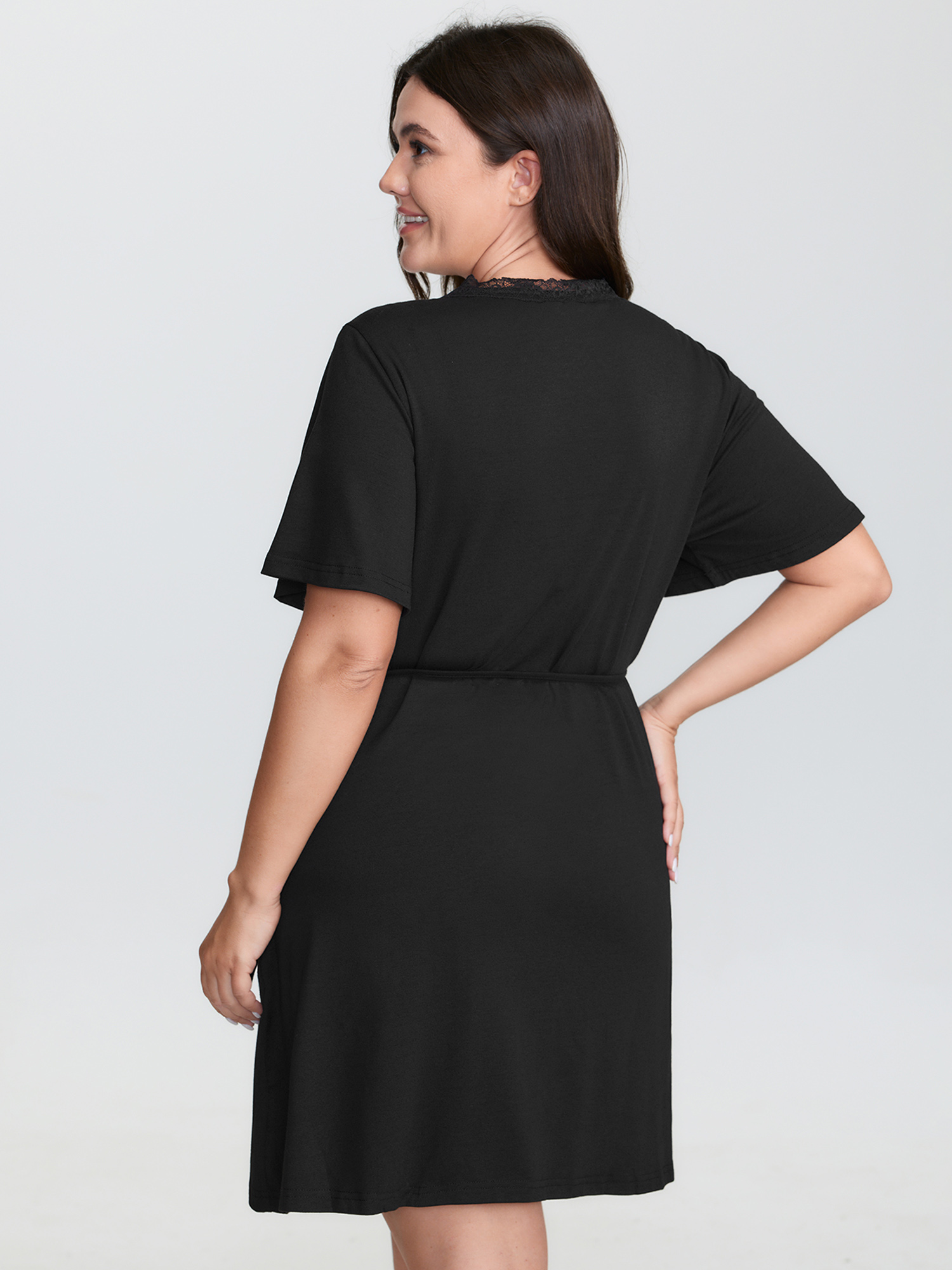 Side view of BloomChic Women's Plus Size Lace Trim Side-Tie Pockets Nightgown Black Short sleeve Mini V-Neck 30/6X