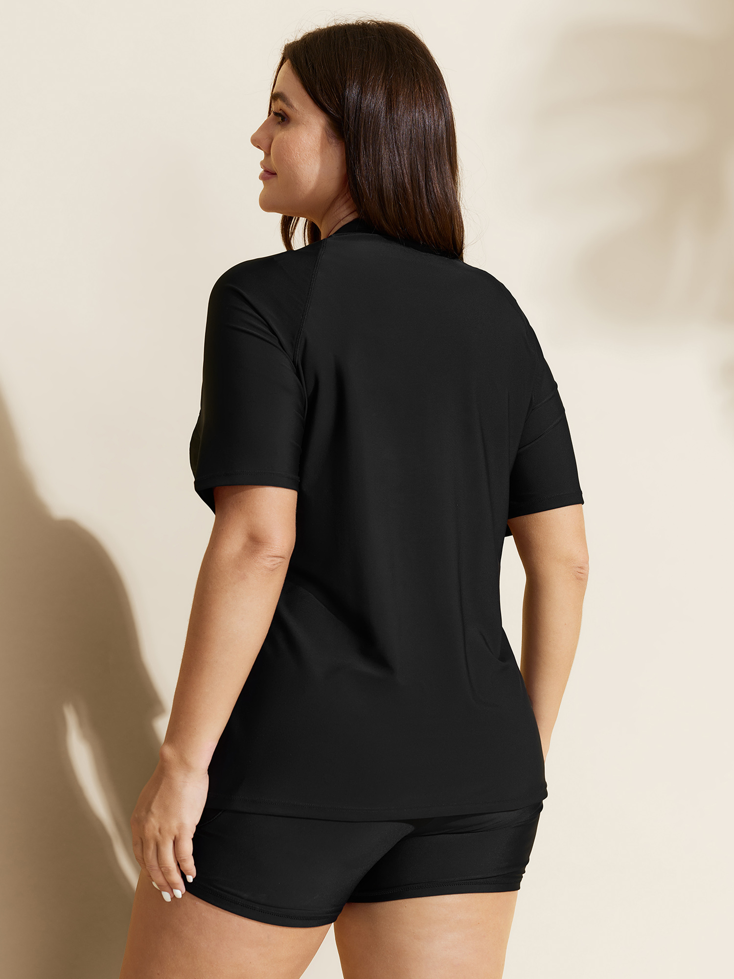 Side view of BloomChic Women's Plus Size UPF 50+ Zipper Front Pockets Swim Top Black Short sleeve 30/6X