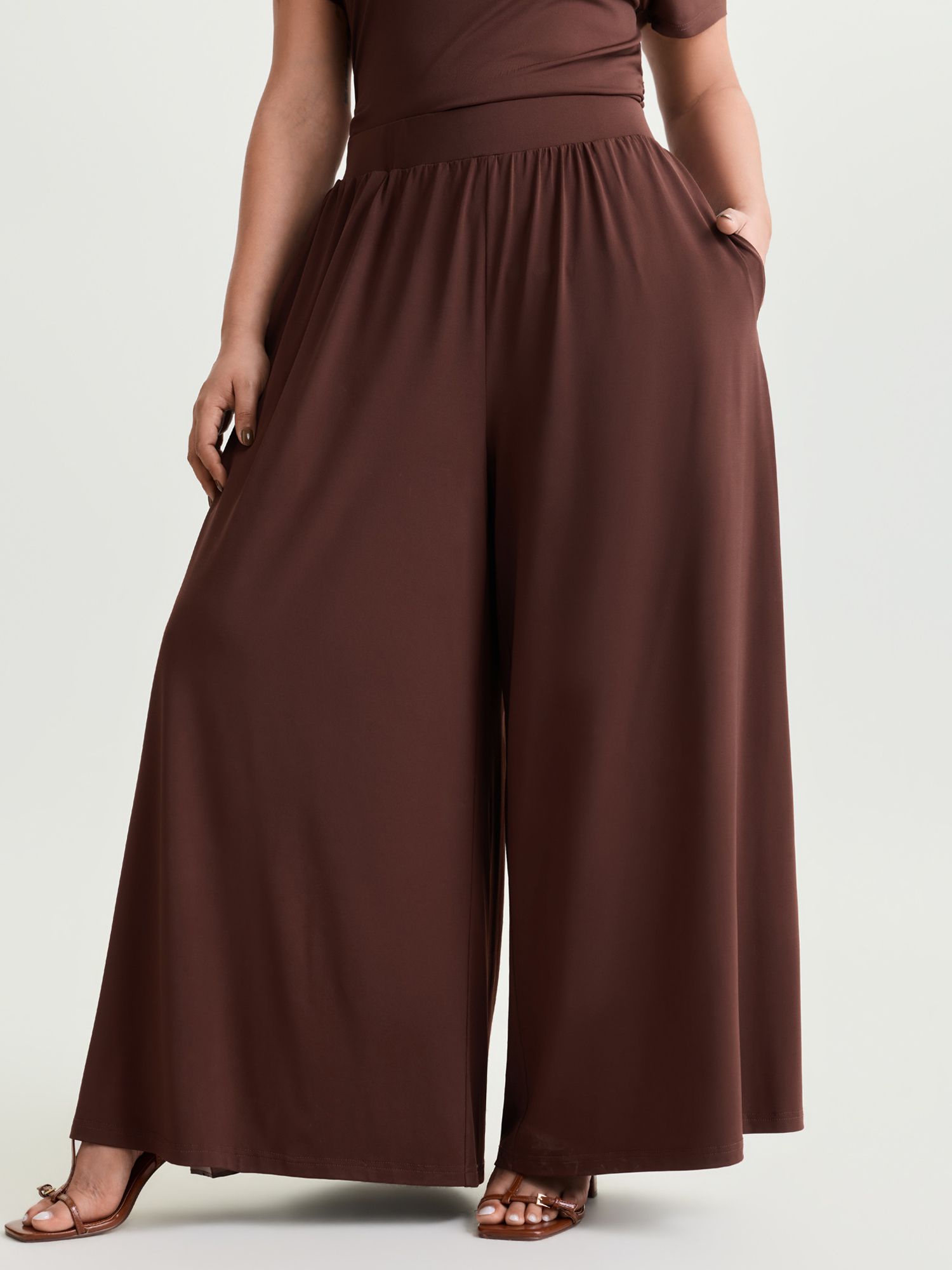 Side view of BloomChic Women's Plus Size Supersoft Stretchy Pleated Flared Plain Pants Browncoffeecolor Solid Flared Mid Rise Elegant 30/6X