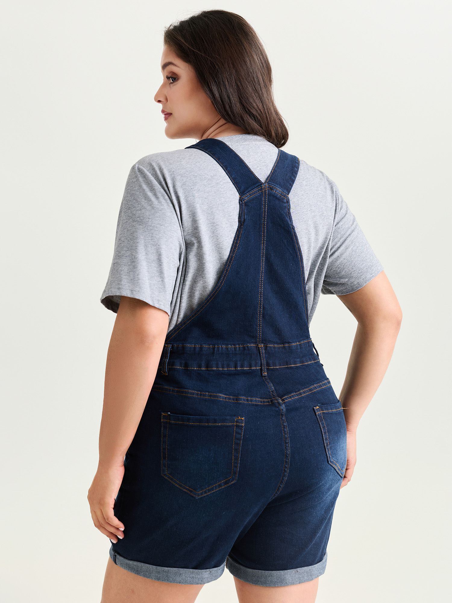 Side view of BloomChic Women's Plus Size Stretchy Pockets Skinny-Fit Denim Overall Romper Darkindigo Casual 28/5X