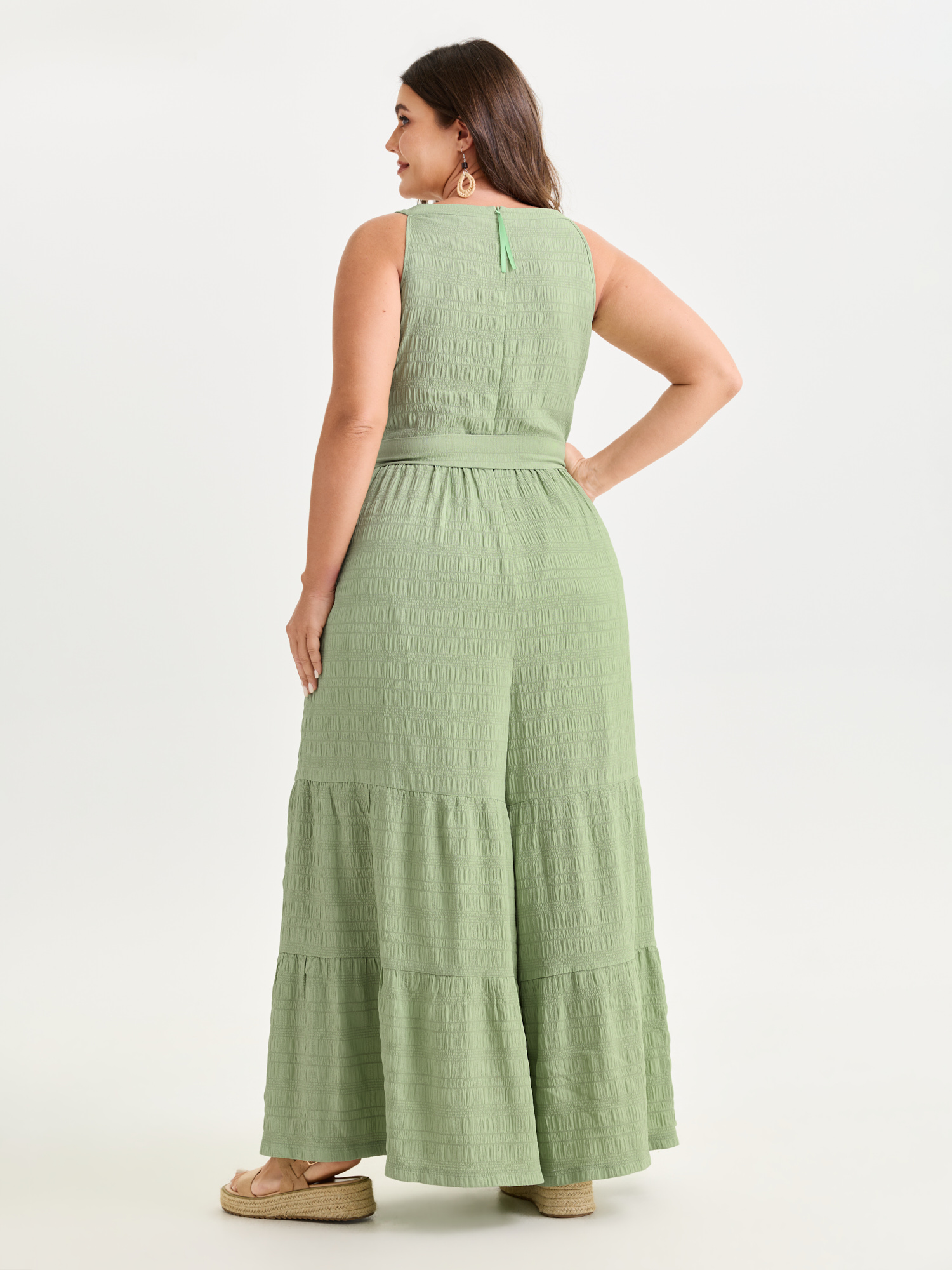 Side view of BloomChic Women's Plus Size Sheer Lace Neckline Ruffled Hem Jumpsuit Greenbean Vacation 14-16/1X