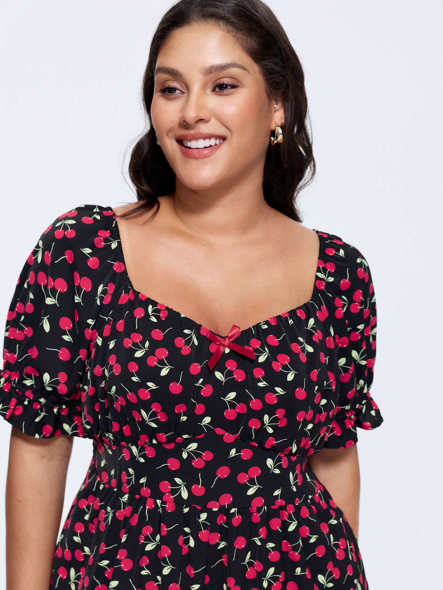 Side view of BloomChic Women's Plus Size Cherry Print Puffy Sleeve Lace Romper Black Elegant Fitted 14-16/1X