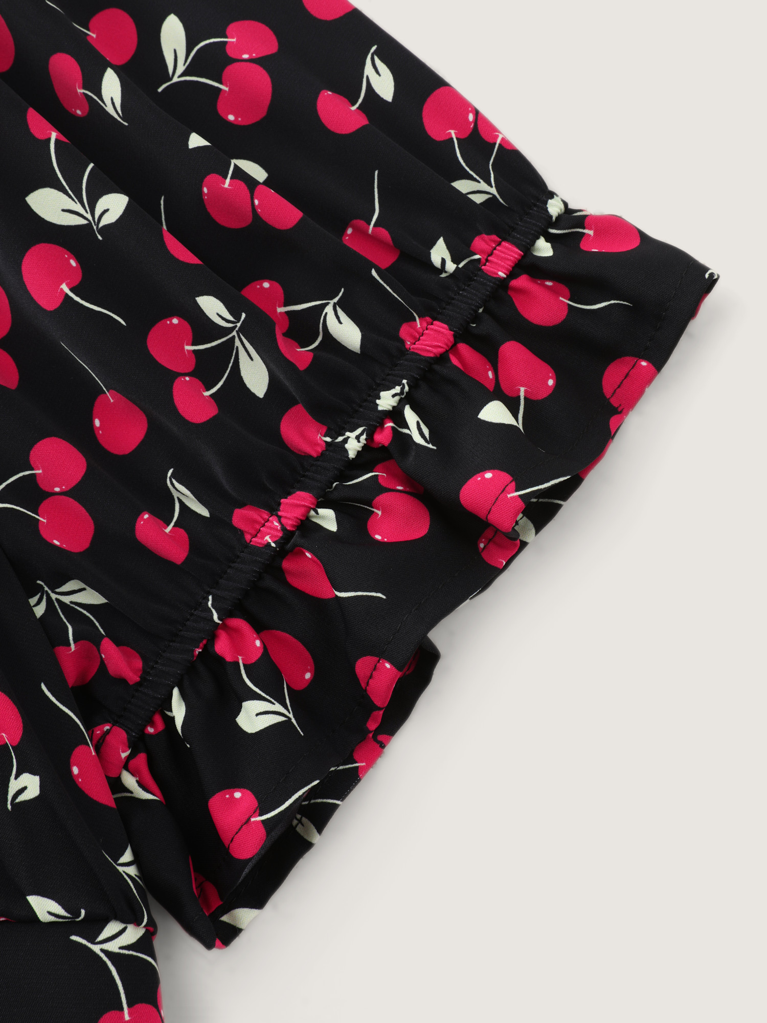 Side view of BloomChic Women's Plus Size Cherry Print Puffy Sleeve Lace Romper Black Elegant Fitted 14-16/1X