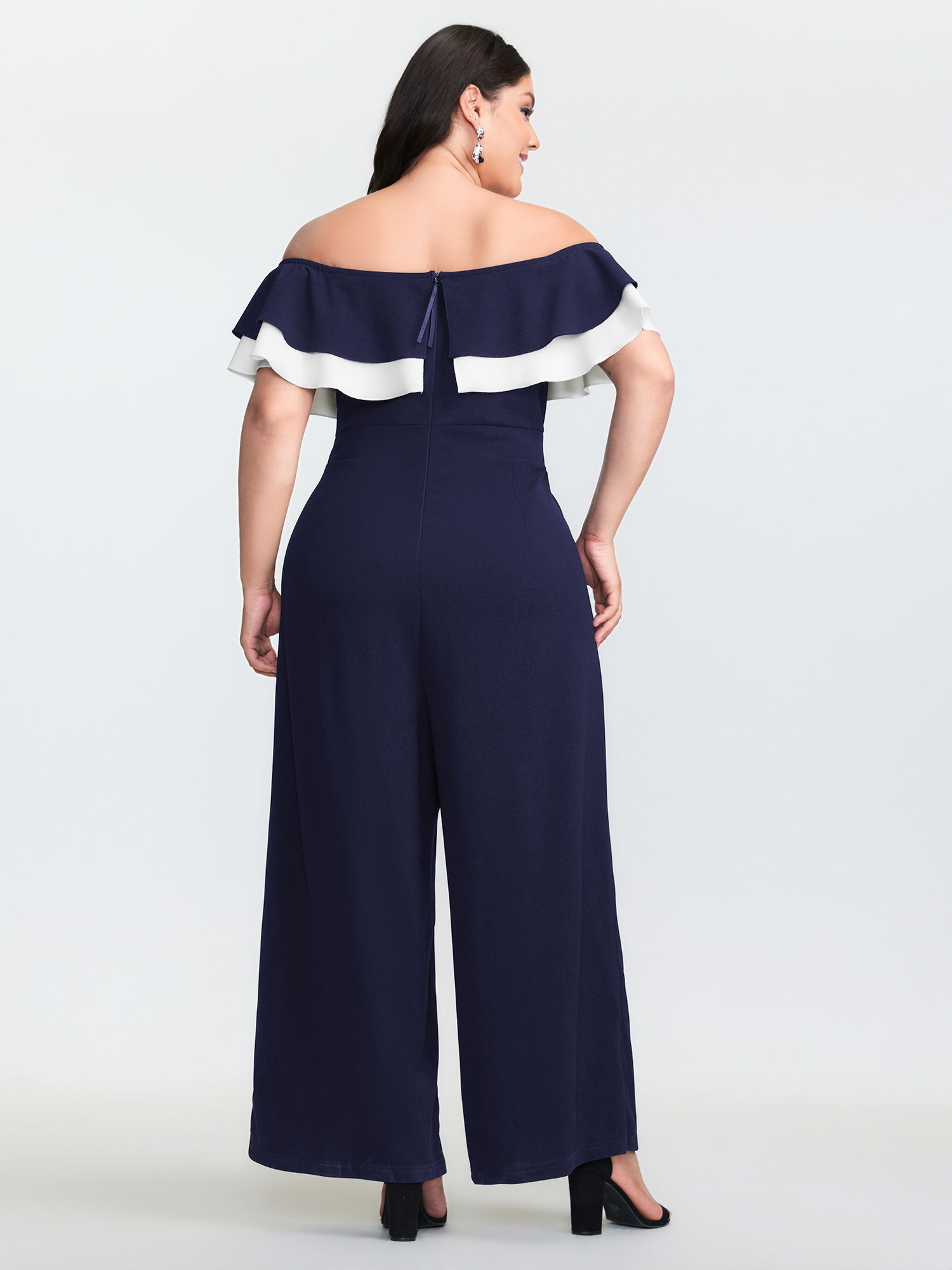 Side view of BloomChic Women's Plus Size Off-Shoulder Lotus Leaf Neckline Jumpsuit DarkBlue Elegant Fitted 12/L
