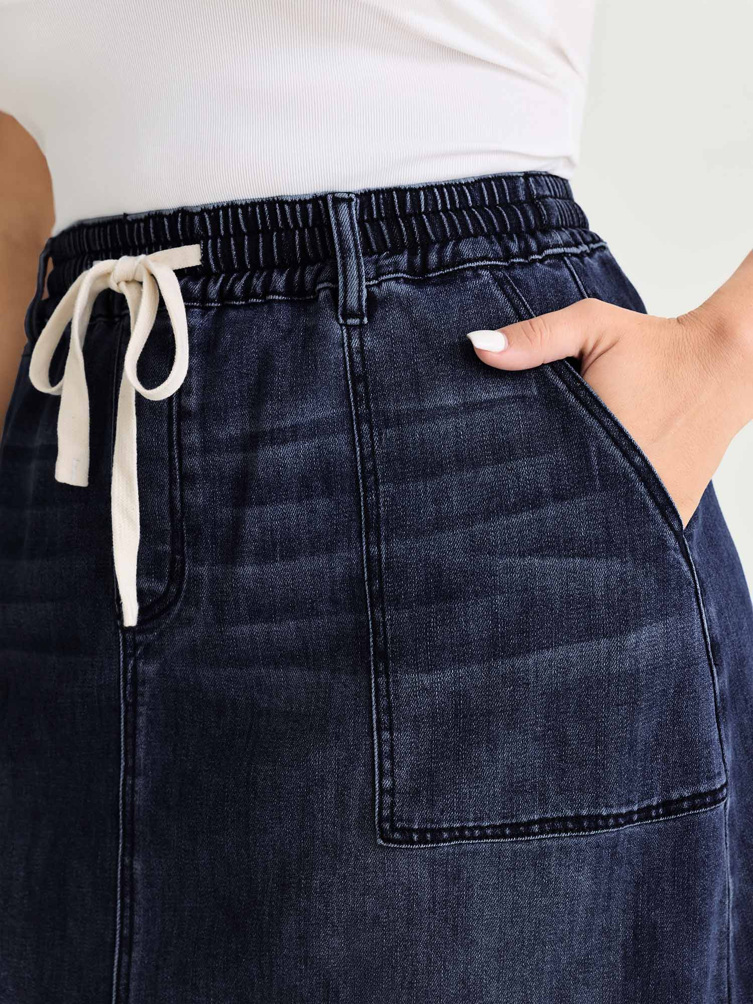 Side view of BloomChic Women's Plus Size Stretchy Contrast Drawstring Waist Midi Denim Skirt Denimindigo 18-20/2X