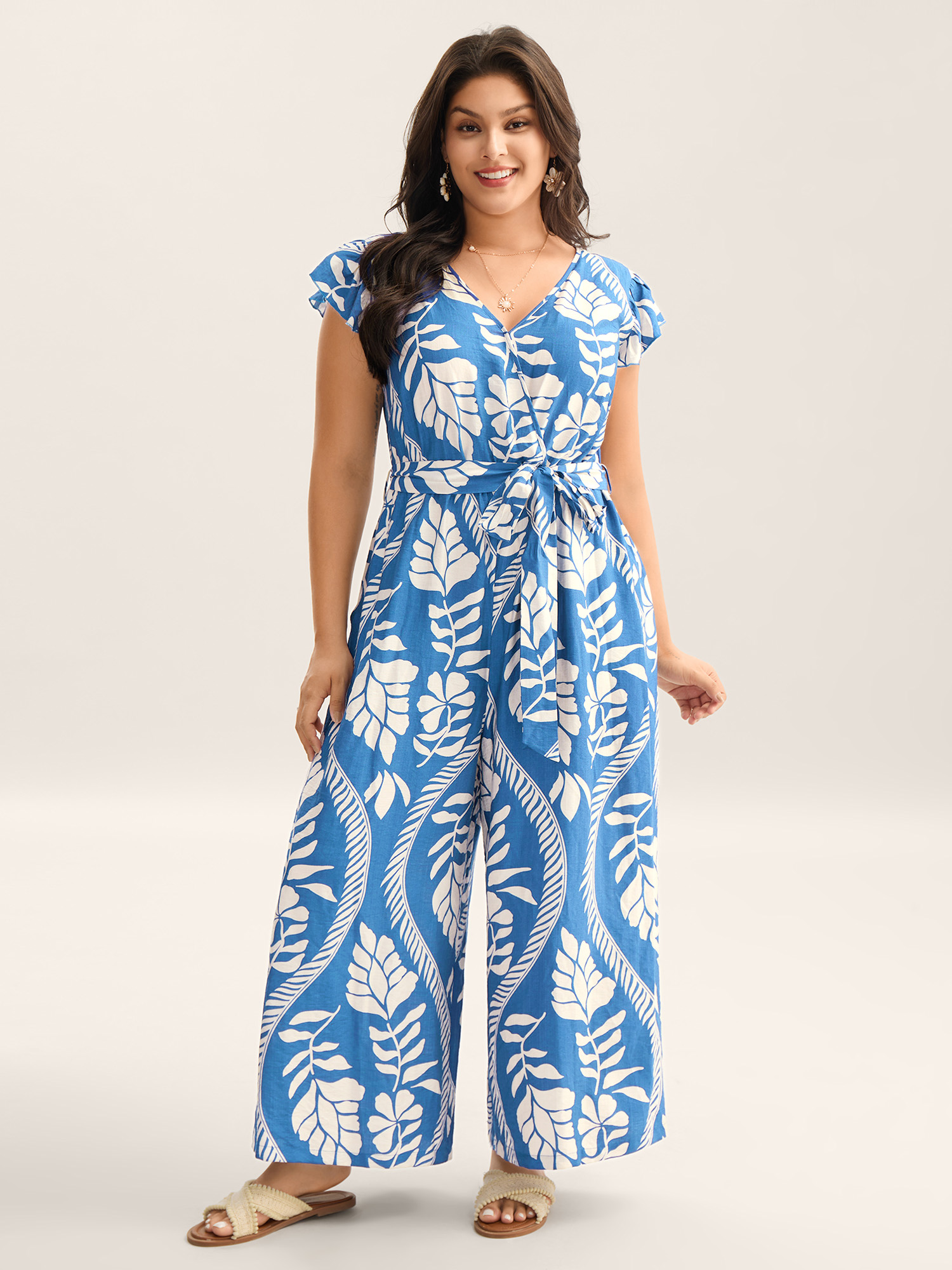 Side view of BloomChic Women's Plus Size Large Floral Print Pockets Jumpsuit LightBlue Vacation 14-16/1X