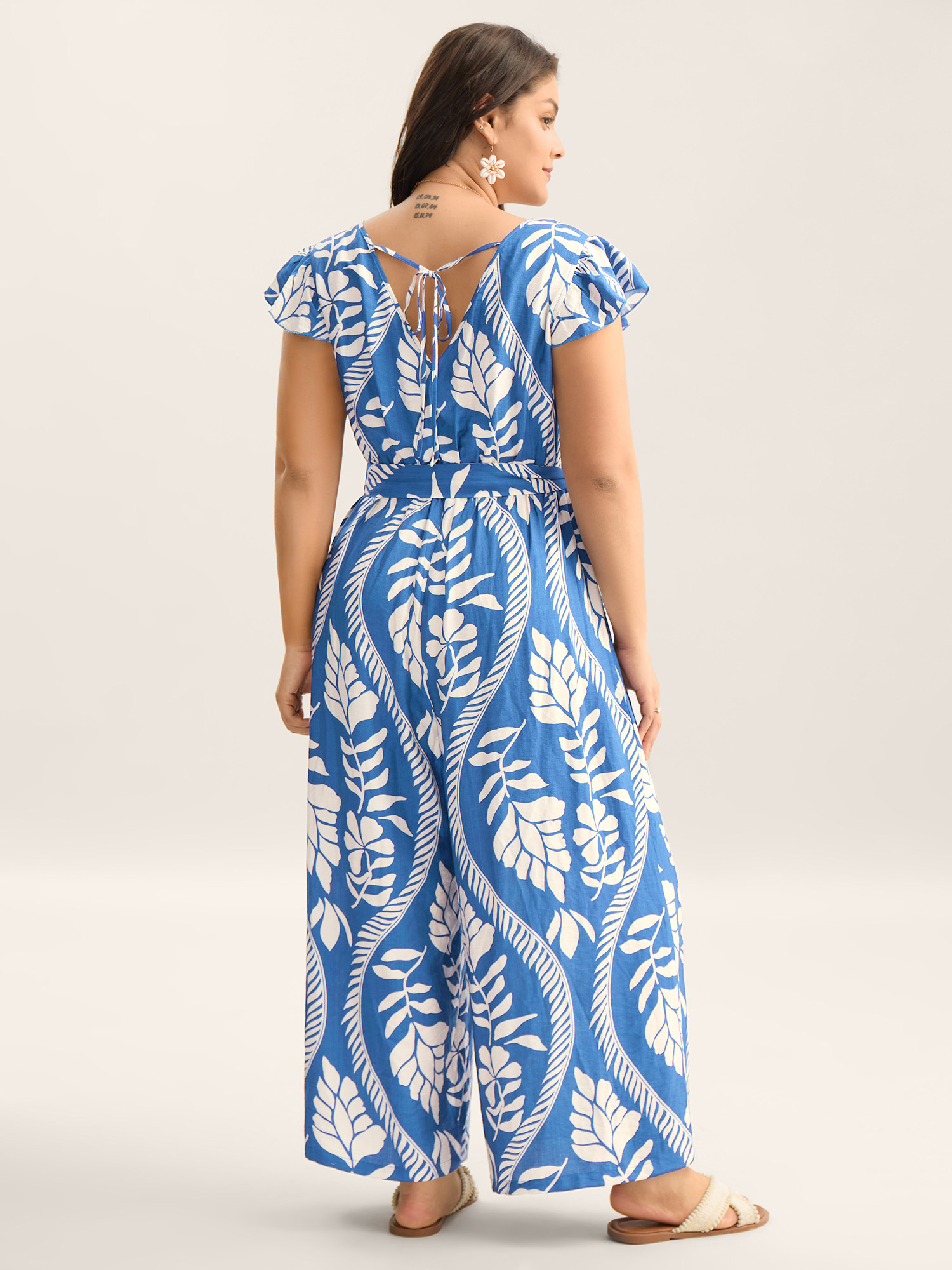 Side view of BloomChic Women's Plus Size Large Floral Print Pockets Jumpsuit LightBlue Vacation 14-16/1X