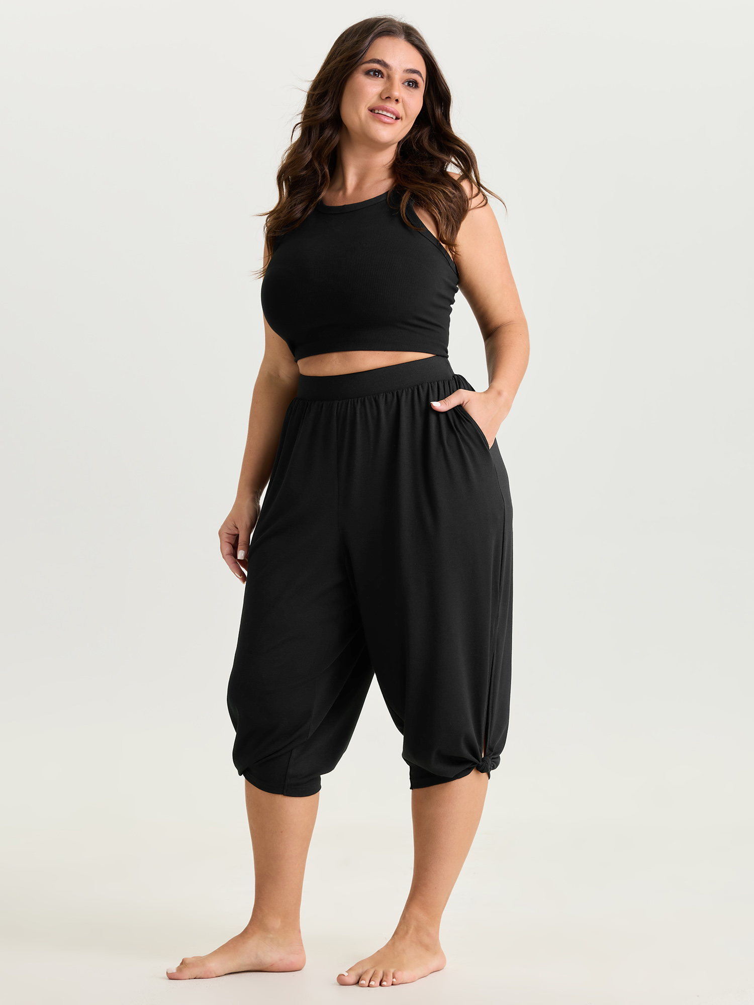 Side view of BloomChic Women's Plus Size Supersoft Stretchy Cuffed Cropped Lounge Bottoms Black Capri 14-16/1X