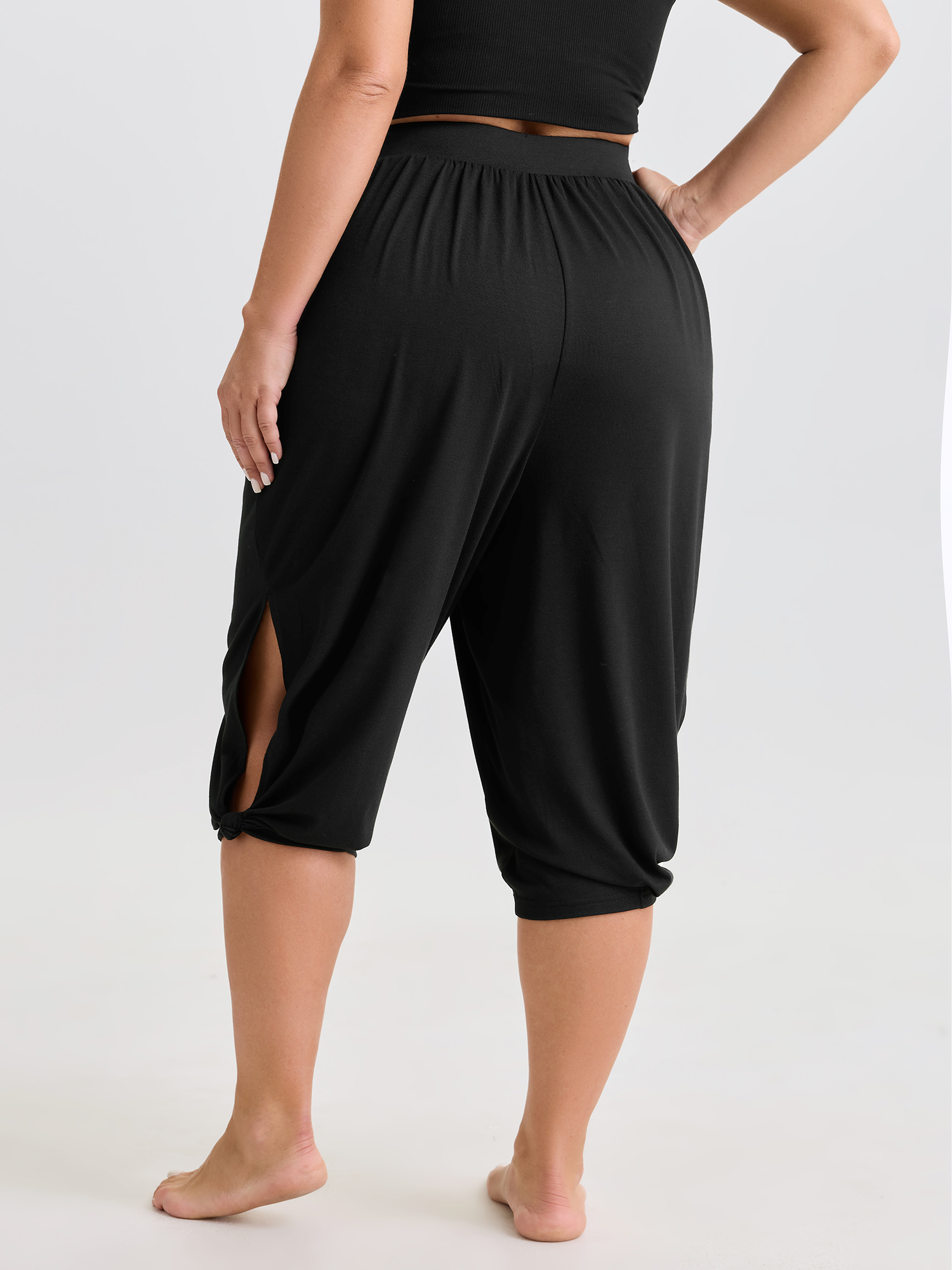 Side view of BloomChic Women's Plus Size Supersoft Stretchy Cuffed Cropped Lounge Bottoms Black Capri 14-16/1X