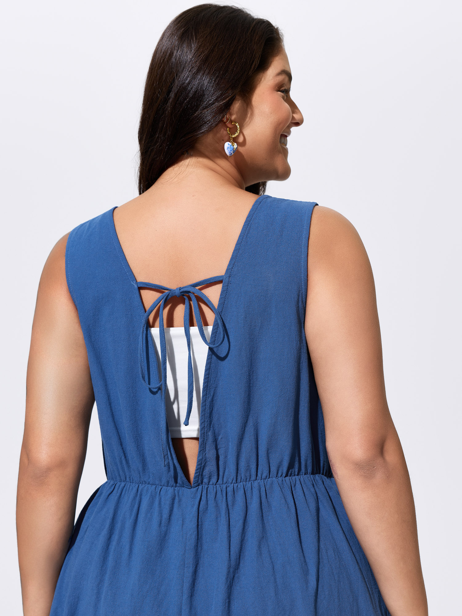 Side view of BloomChic Women's Plus Size Cotton Pleated Open Back-Ties Plain Romper Mediumblue Vacation 10/M