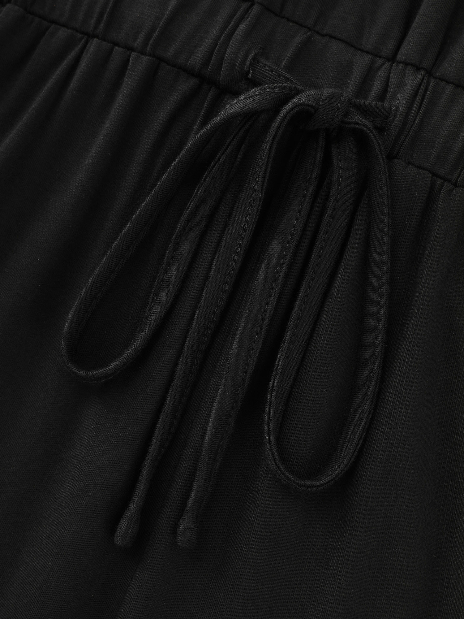 Side view of BloomChic Women's Plus Size Supersoft V-Neck Drawstring Romper Black Casual 10/M