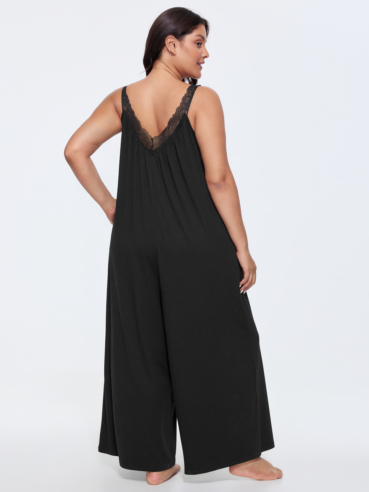 Side view of BloomChic Women's Plus Size Supersoft Stretchy Sheer Neckline Relaxed-Fit Lounge Jumpsuit Black not graphics 14-16/1X