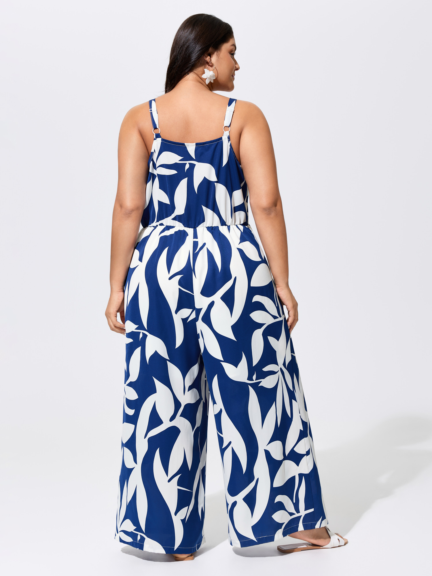 Side view of BloomChic Women's Plus Size Silhouette Floral Print Sweetheart Jumpsuit Indigo Vacation 22-24/3X
