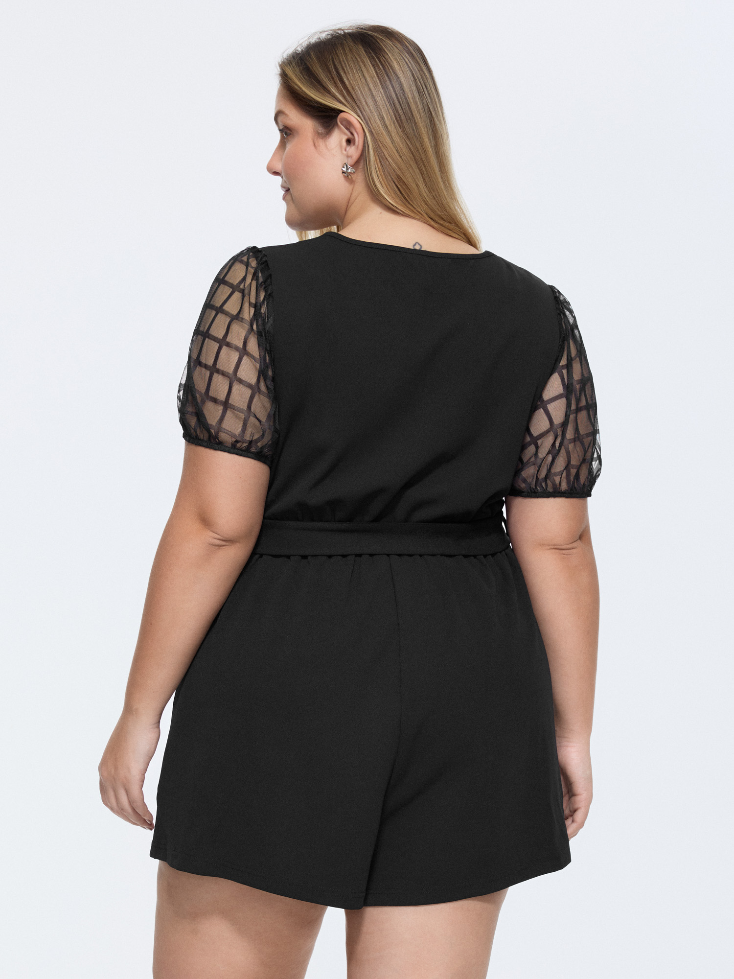 Side view of BloomChic Women's Plus Size Sheer Sleeves Waist-Tie Romper Pureblack Office 14-16/1X