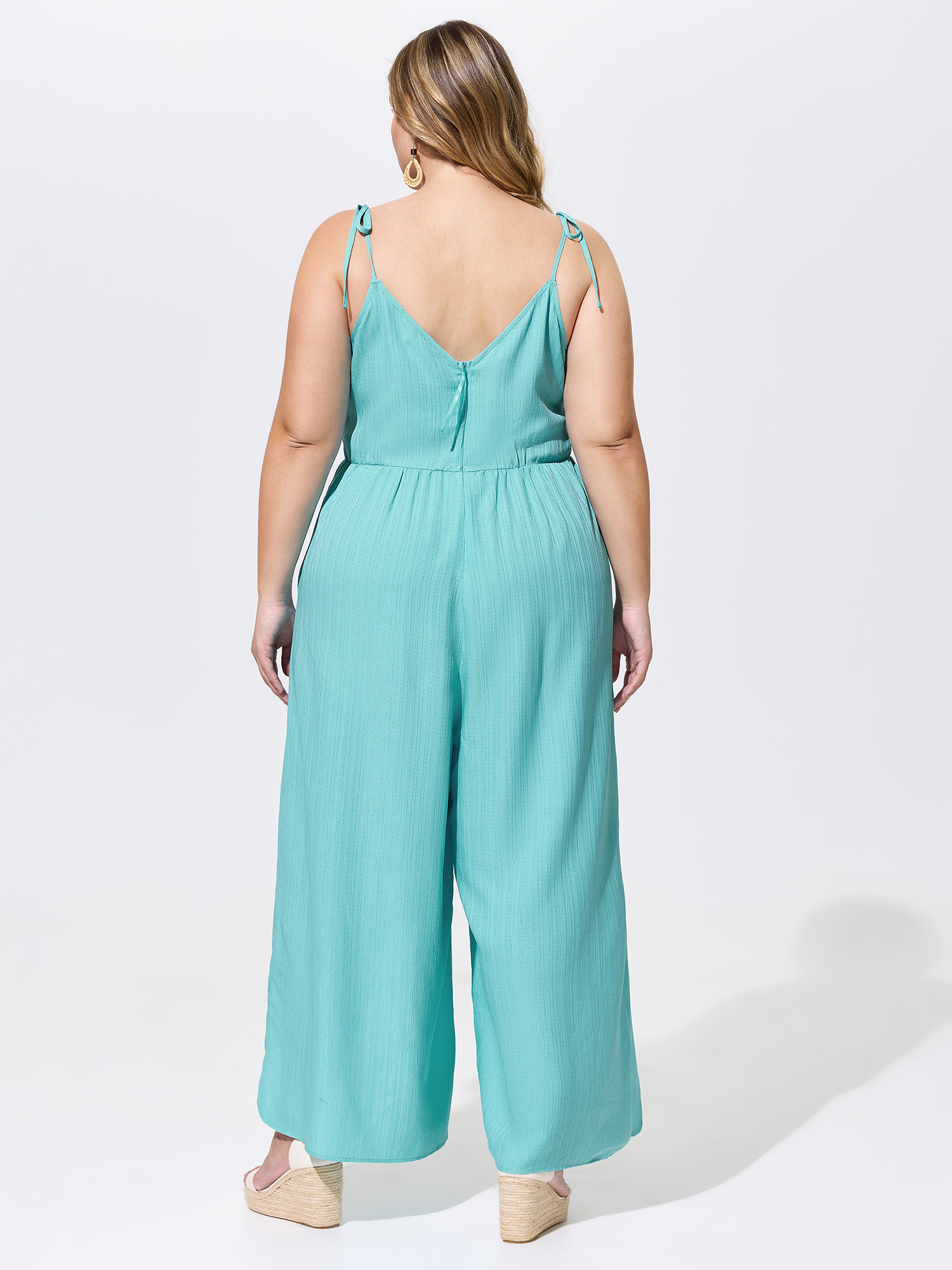 Side view of BloomChic Women's Plus Size Elastic Waist Petal Split Hem Jumpsuit Arctic Vacation 26/4X