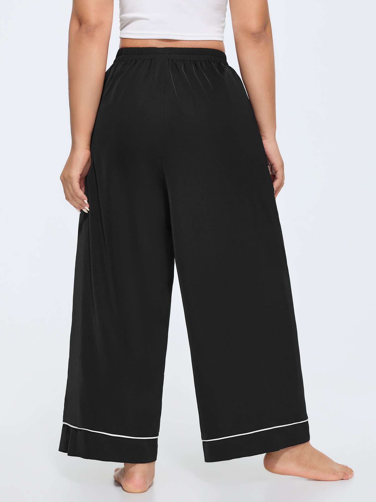 Side view of BloomChic Women's Plus Size Color Contrast Hem Straight-Leg Lounge Pants Black 14-16/1X