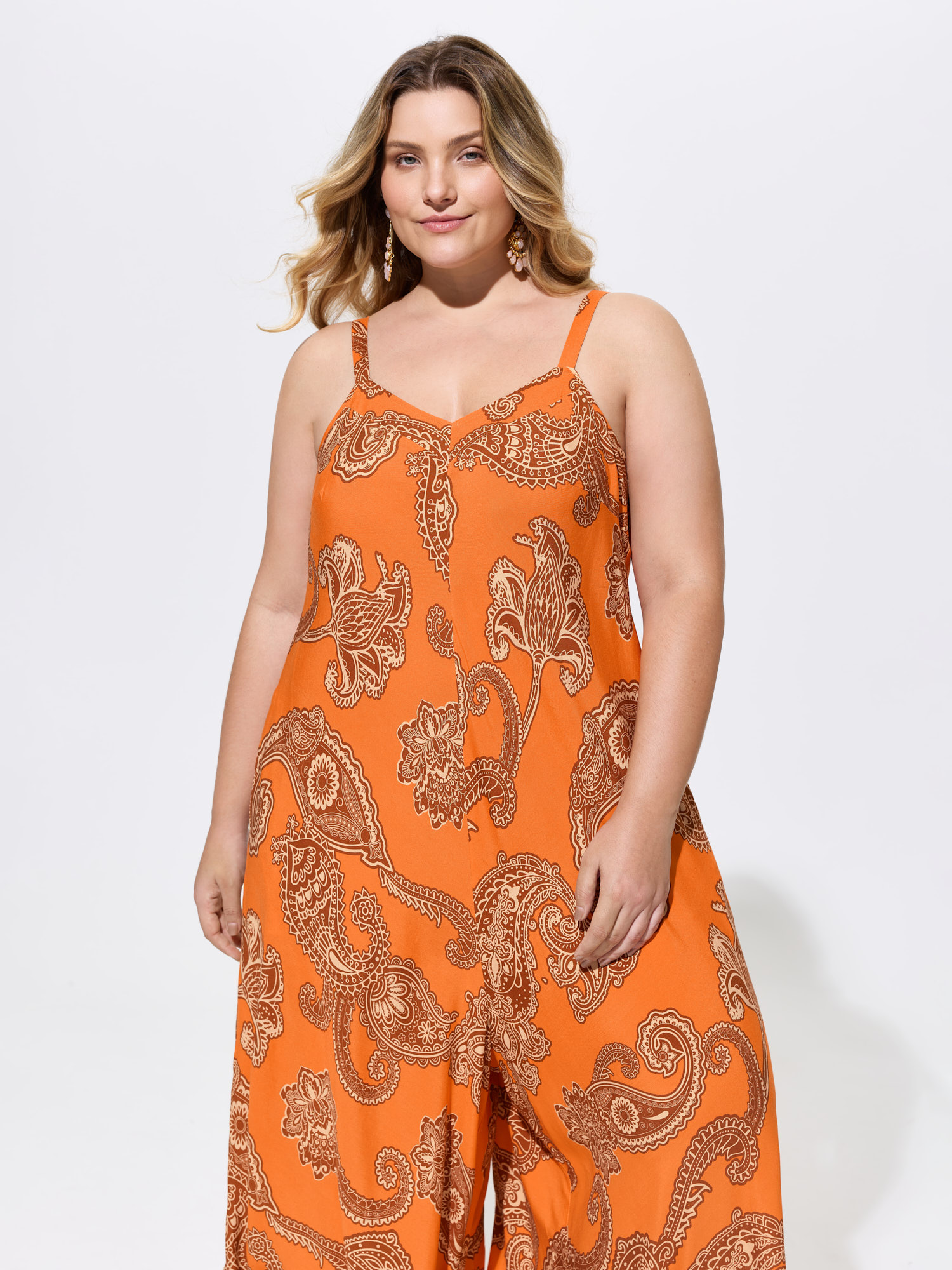 Side view of BloomChic Women's Plus Size Boho Print Asymmetrical Hem Jumpsuit Brightorange Vacation 12/L