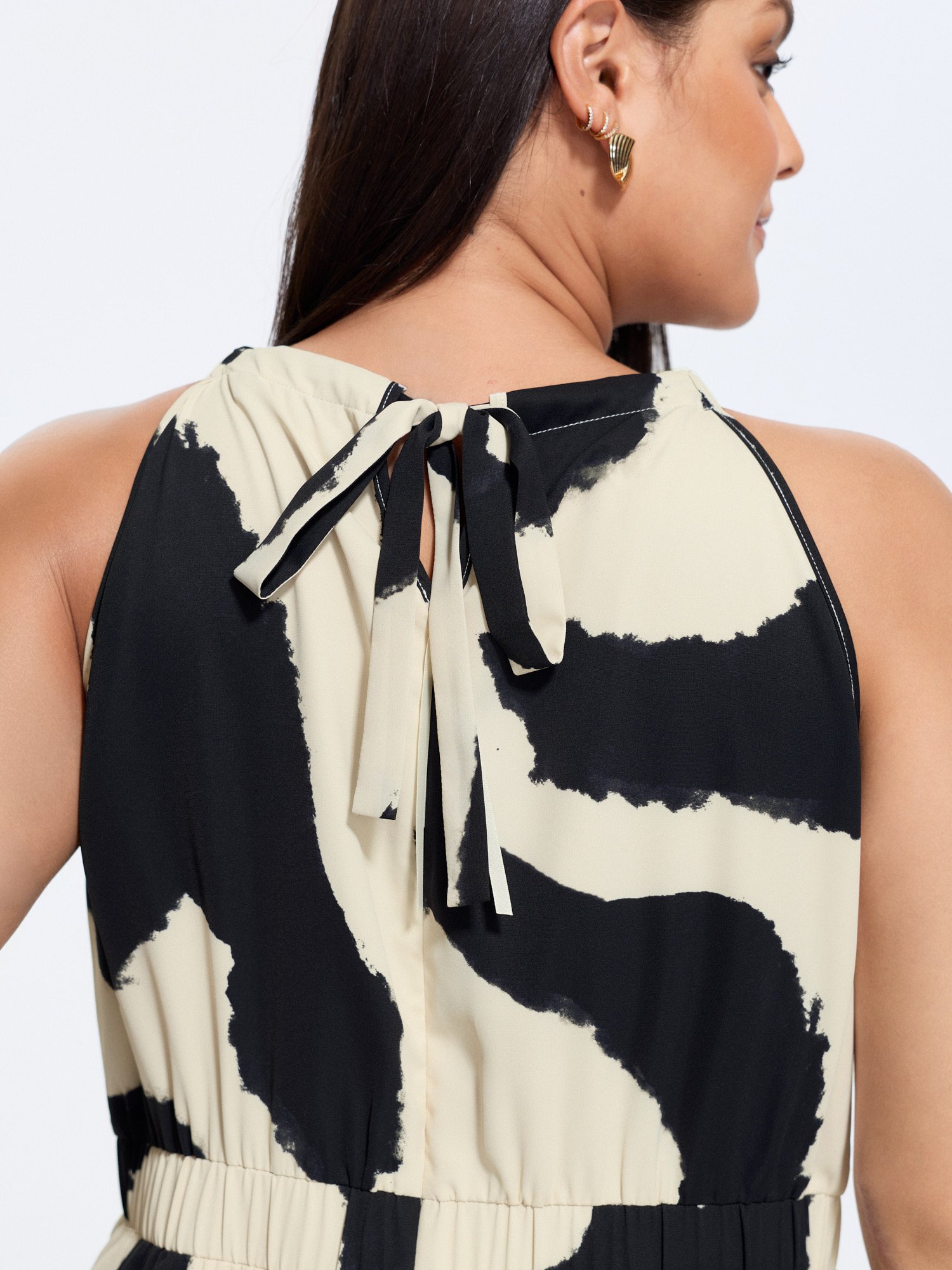 Side view of BloomChic Women's Plus Size Abstract Floral Print Halter Neckline Jumpsuit Beige Office Fitted 30/6X