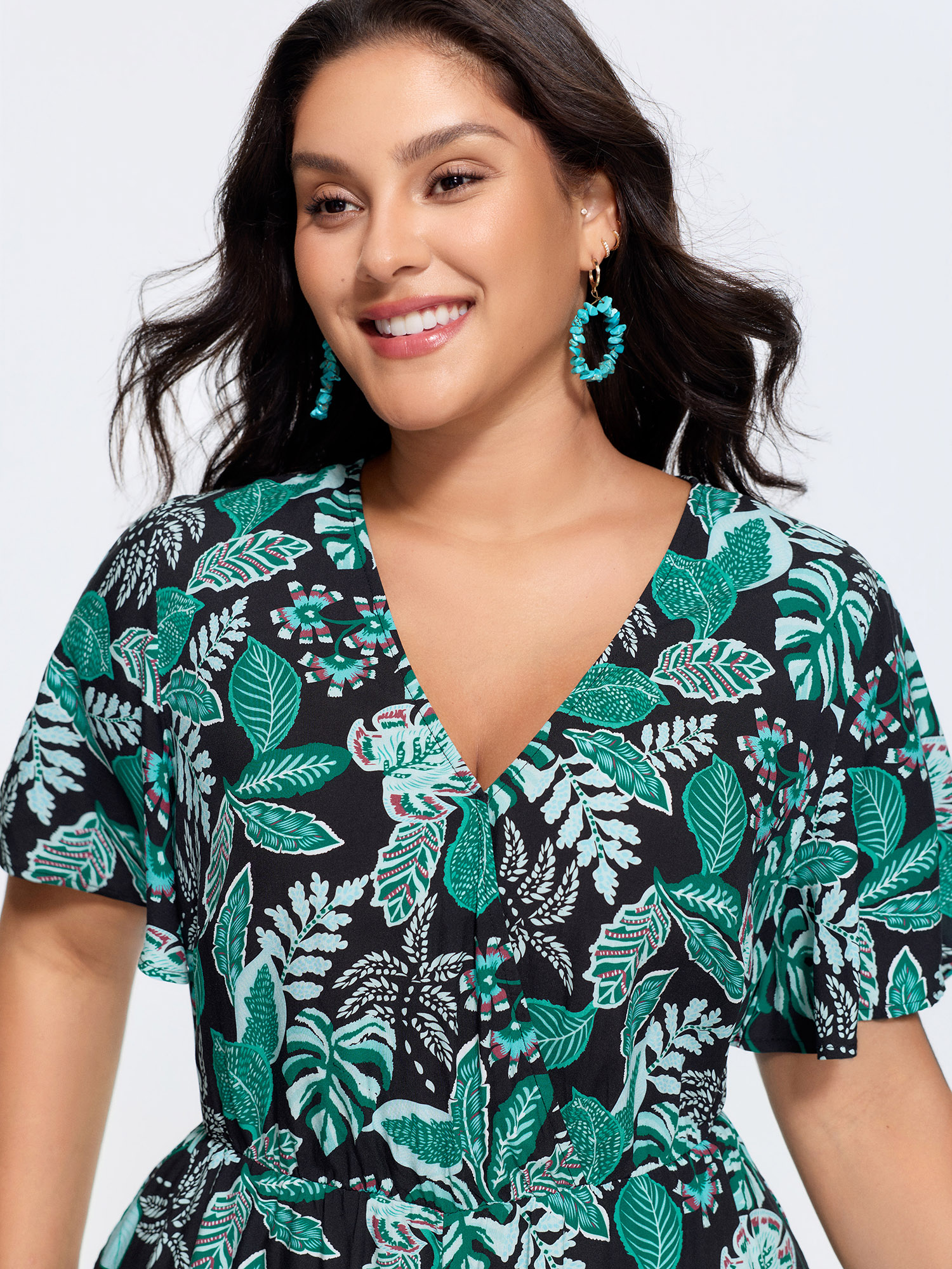 Side view of BloomChic Women's Plus Size Tropical Print Cut-Out Back Romper Black Vacation 14-16/1X