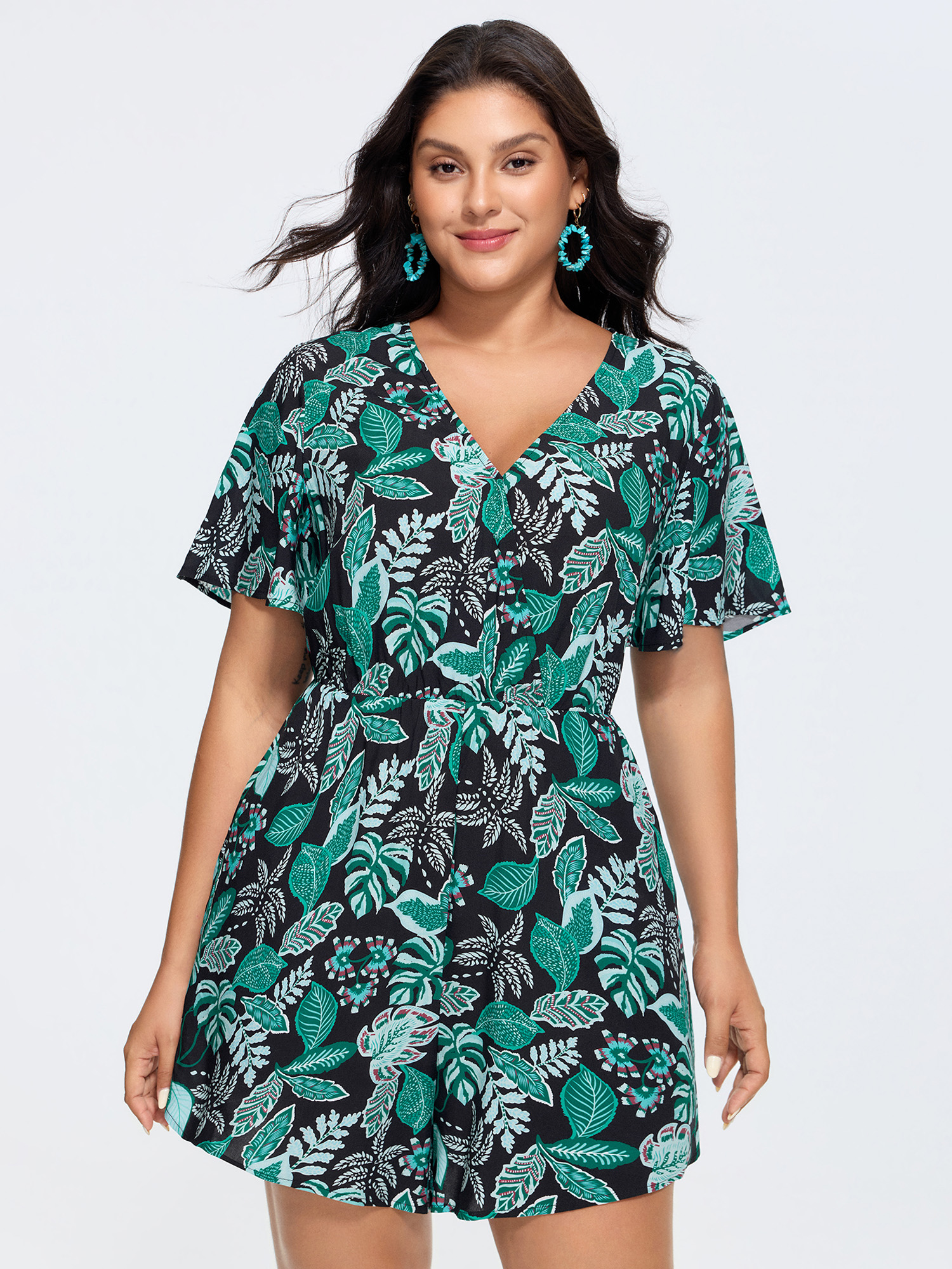 Side view of BloomChic Women's Plus Size Tropical Print Cut-Out Back Romper Black Vacation 14-16/1X