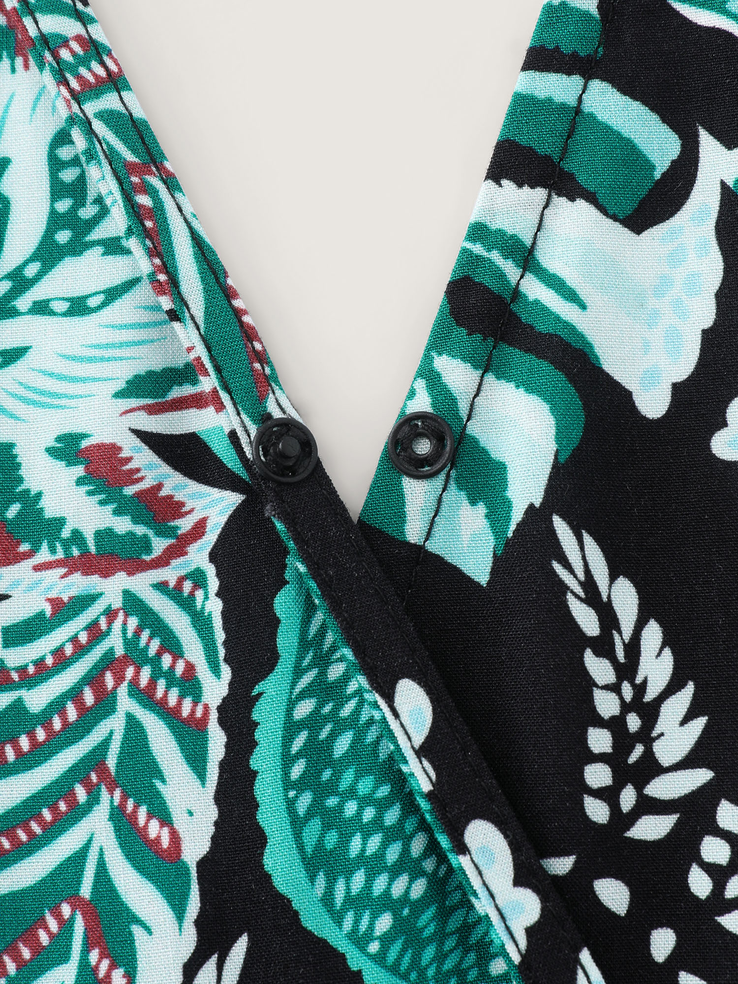 Side view of BloomChic Women's Plus Size Tropical Print Cut-Out Back Romper Black Vacation 14-16/1X