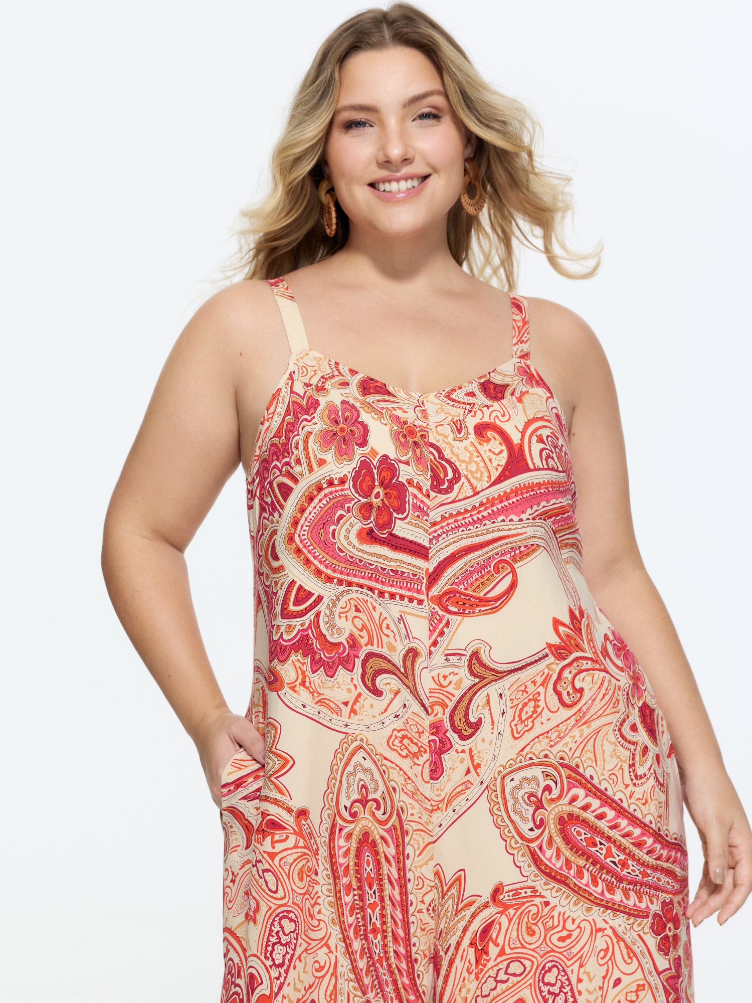 Side view of BloomChic Women's Plus Size Boho Print Asymmetrical Hem Jumpsuit Scarlet Vacation 18-20/2X