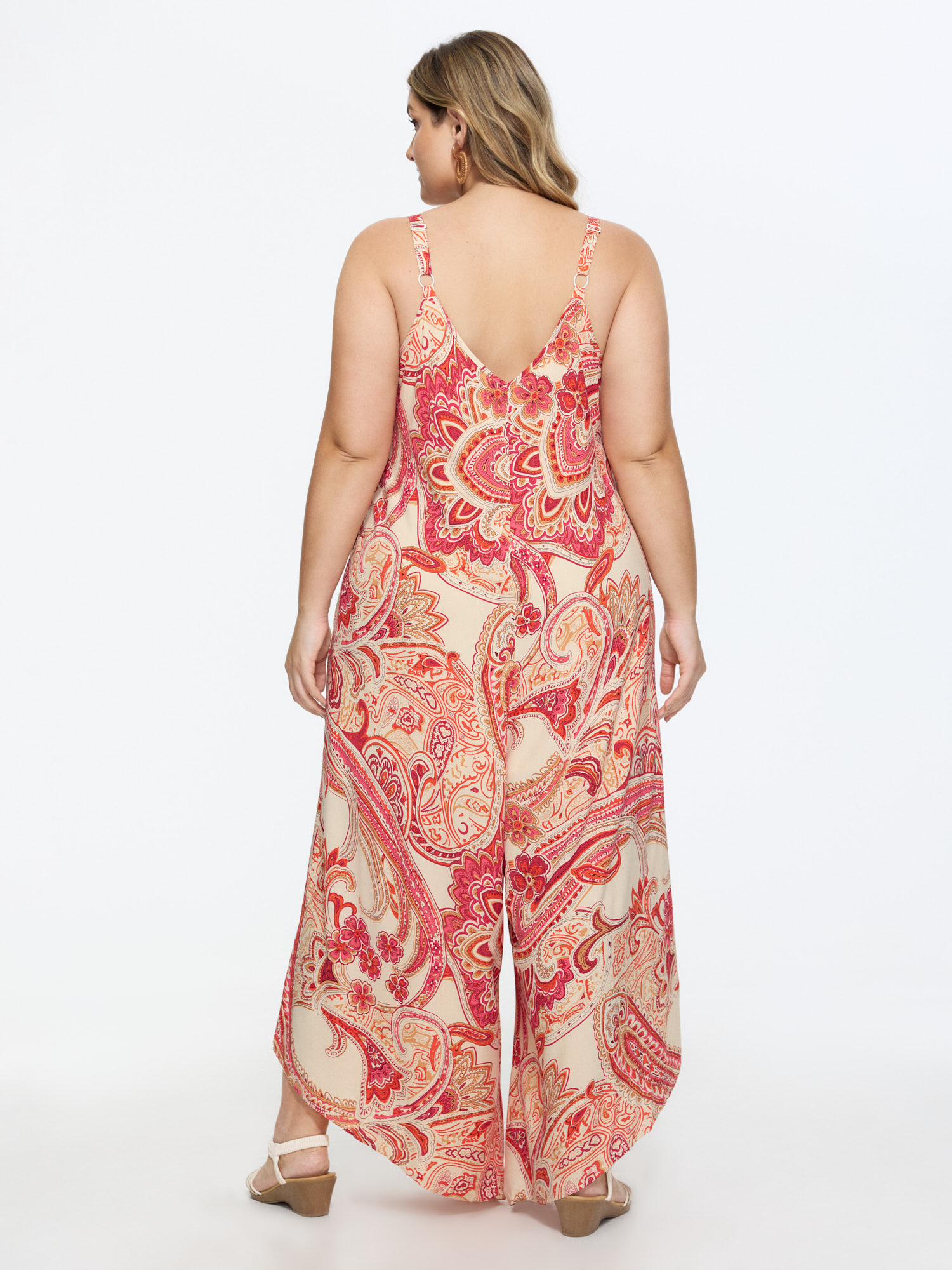 Side view of BloomChic Women's Plus Size Boho Print Asymmetrical Hem Jumpsuit Scarlet Vacation 18-20/2X