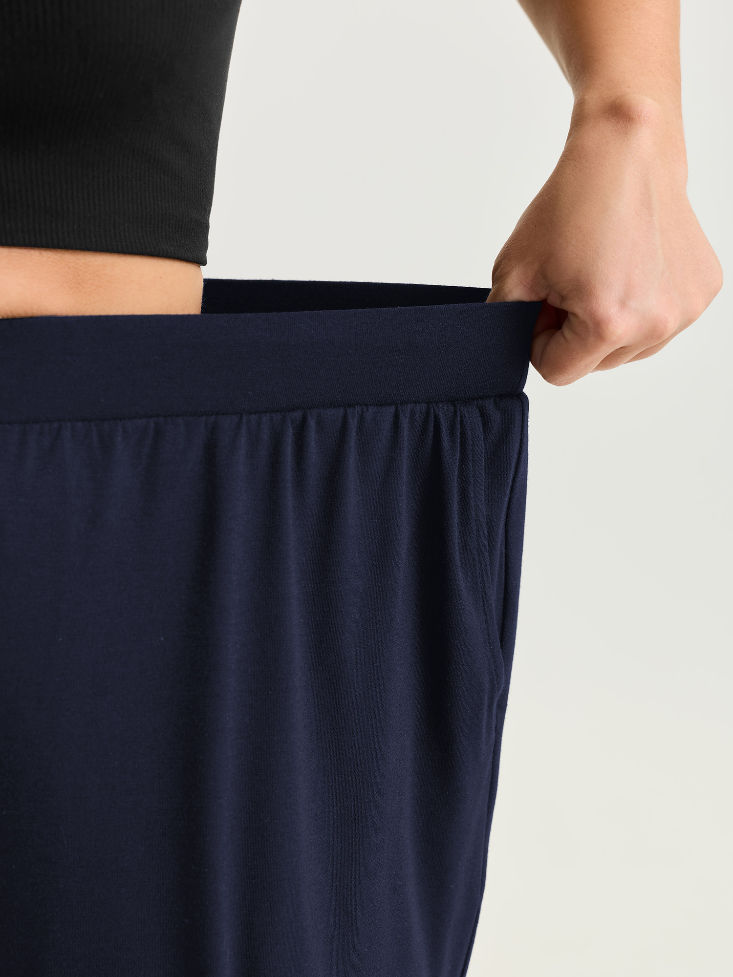 Side view of BloomChic Women's Plus Size Supersoft Stretchy Cuffed Cropped Lounge Bottoms Indigo Capri 18-20/2X