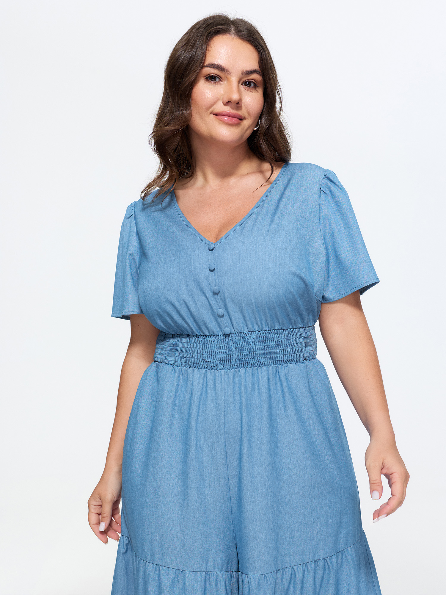 Side view of BloomChic Women's Plus Size Supersoft Button Detail Shirred Waist Faux Denim Jumpsuit Cerulean Casual 14-16/1X