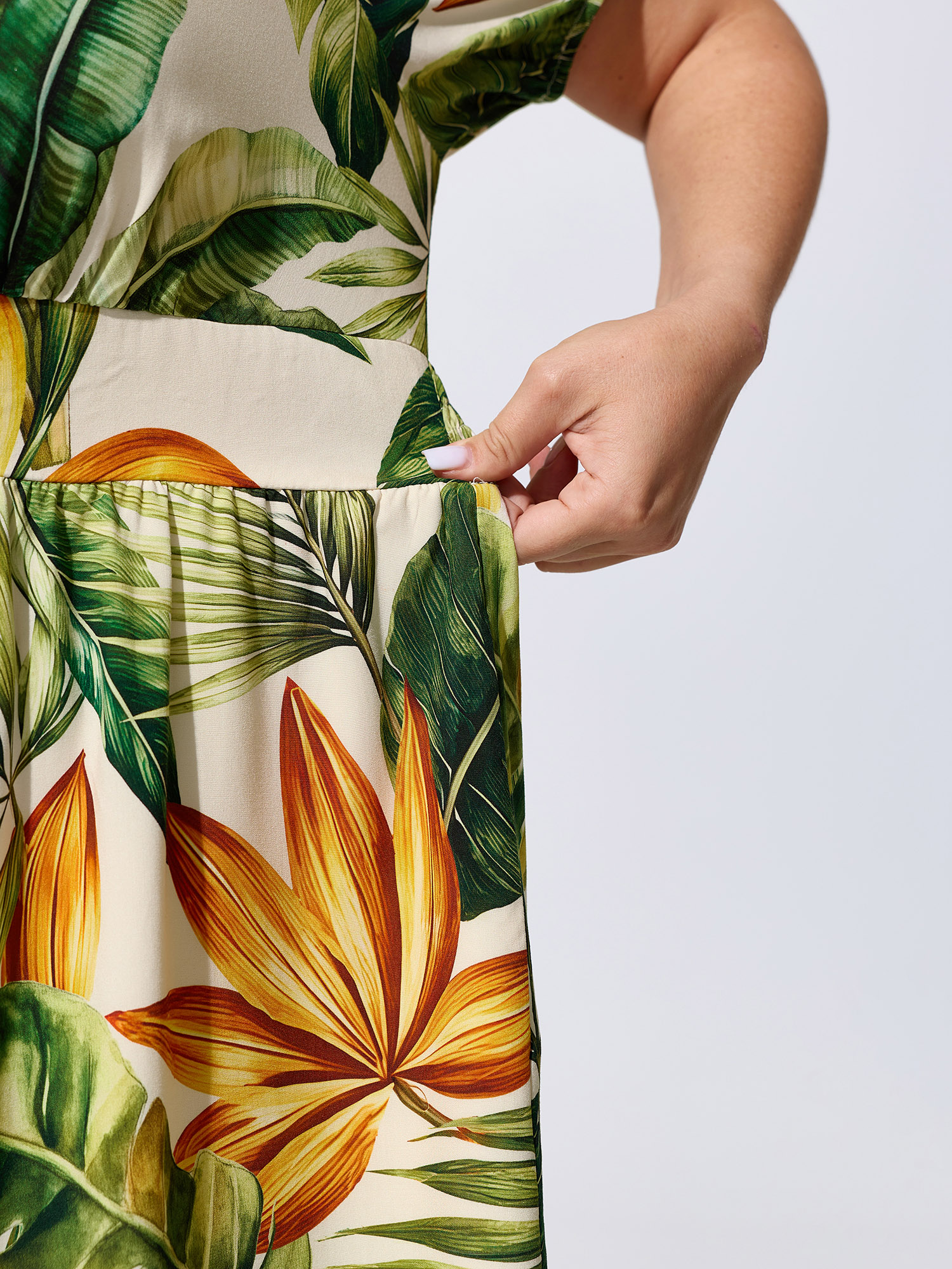 Side view of BloomChic Women's Plus Size Tropical Print Shirred Wide-Leg Romper Truegreen Vacation 26/4X