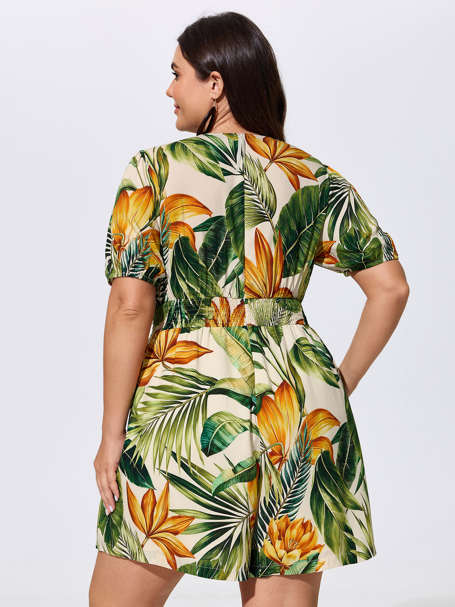 Side view of BloomChic Women's Plus Size Tropical Print Shirred Wide-Leg Romper Truegreen Vacation 26/4X