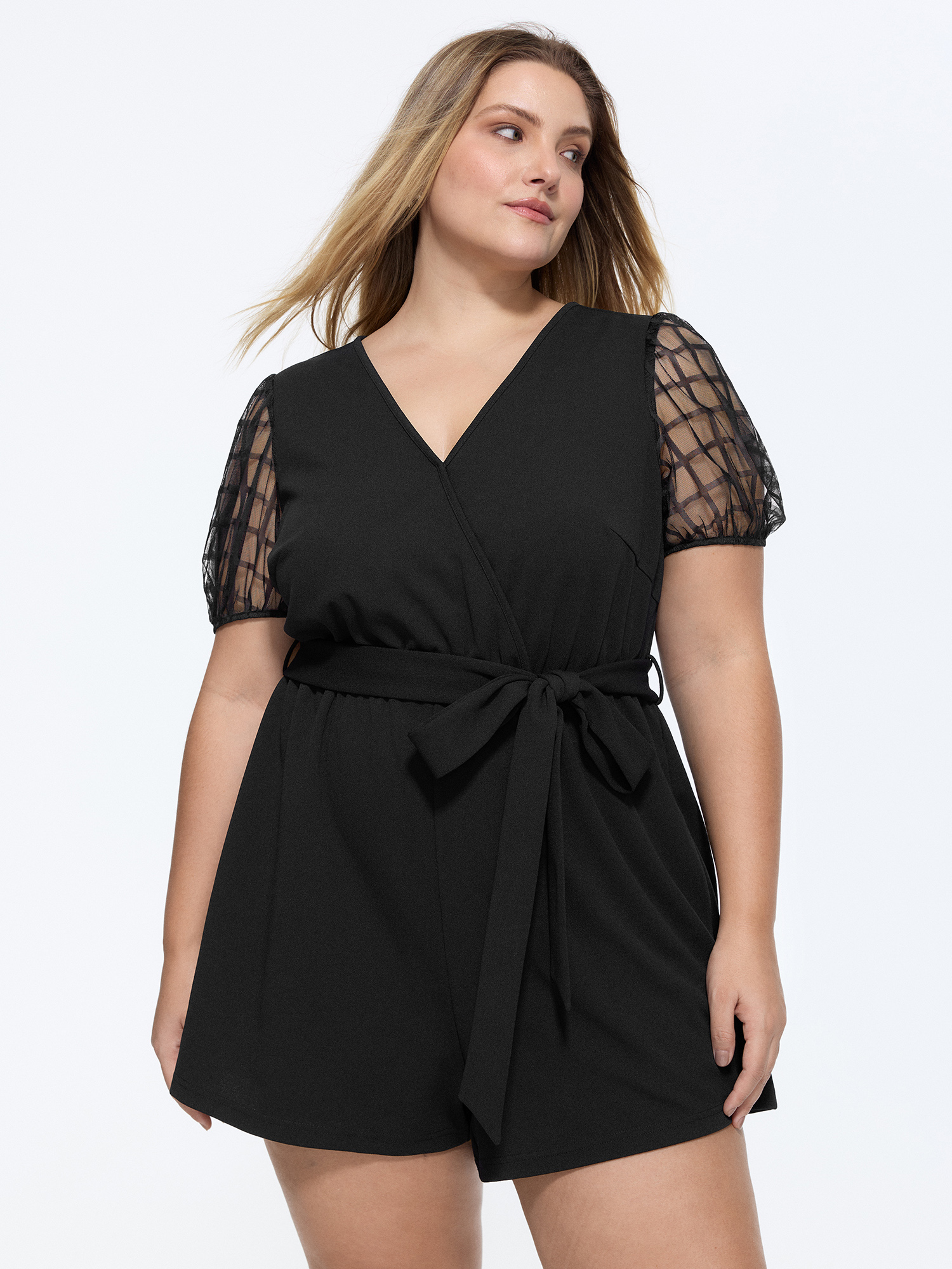 Side view of BloomChic Women's Plus Size Sheer Sleeves Waist-Tie Romper Pureblack Office 14-16/1X
