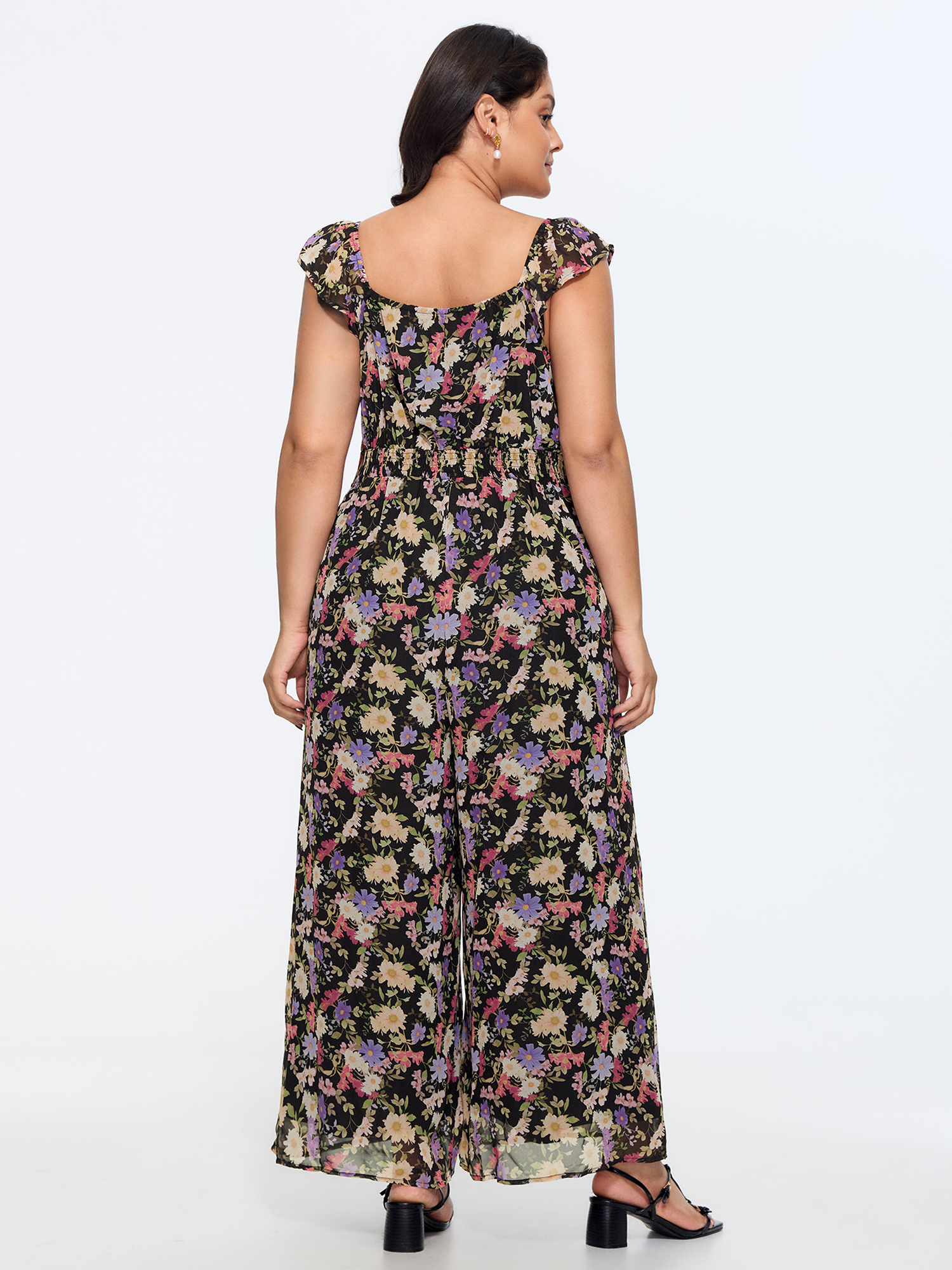 Side view of BloomChic Women's Plus Size Floral Print Shirred Wide-Leg Jumpsuit BlackFlower Elegant Fitted 10/M