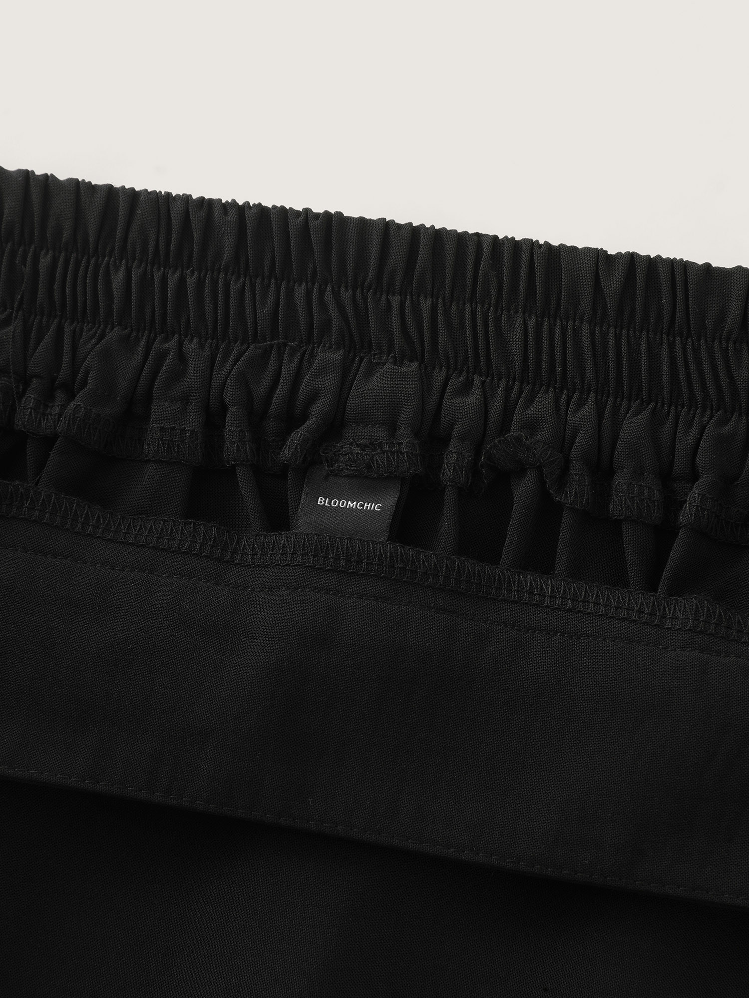 Side view of BloomChic Women's Plus Size Waist Beaded Pleated Flowy Maxi Skirt Black Wide Waistband Flared Office 14-16/1X